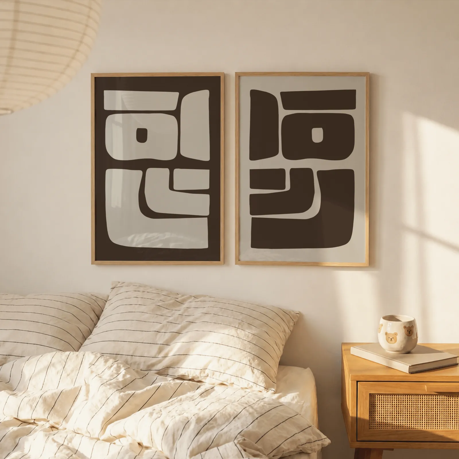 brown beige abstract mid-century wall art set of 2, above a striped linen bed beside a paper lantern shade