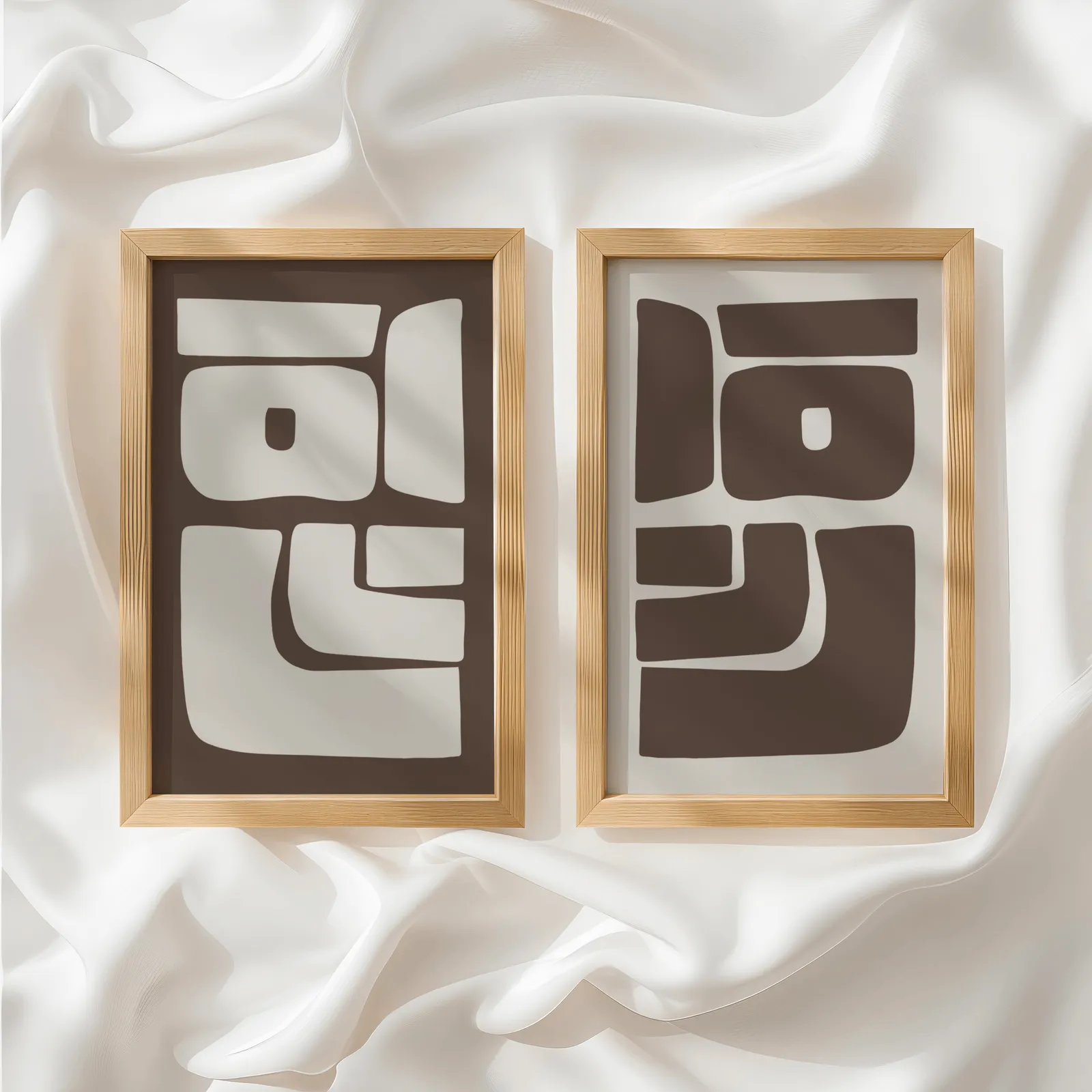 brown beige abstract mid-century wall art set of 2, side by side atop rumpled white silky fabric