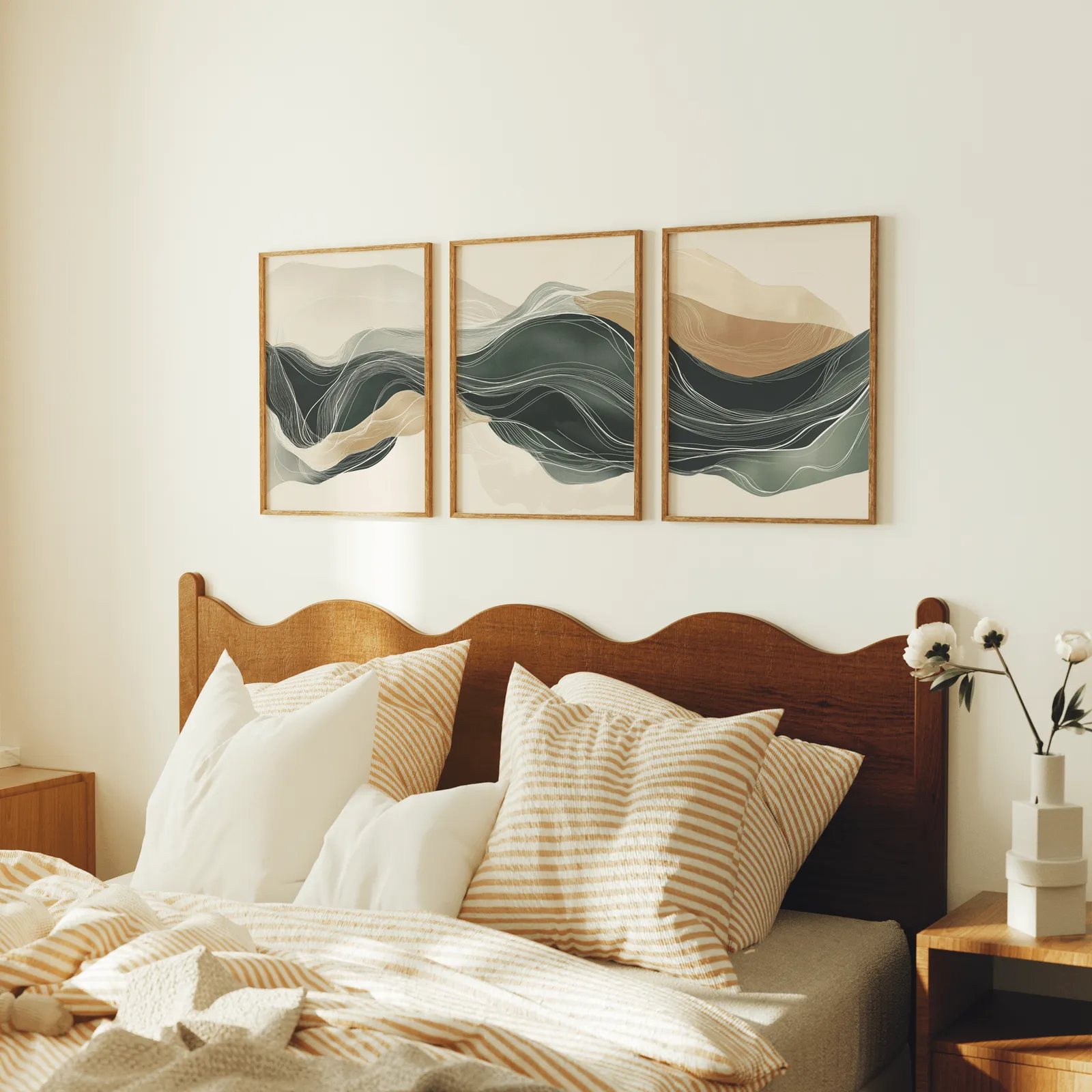 green and beige abstract landscape triptych wall art, above a scalloped wooden headboard with striped pillows