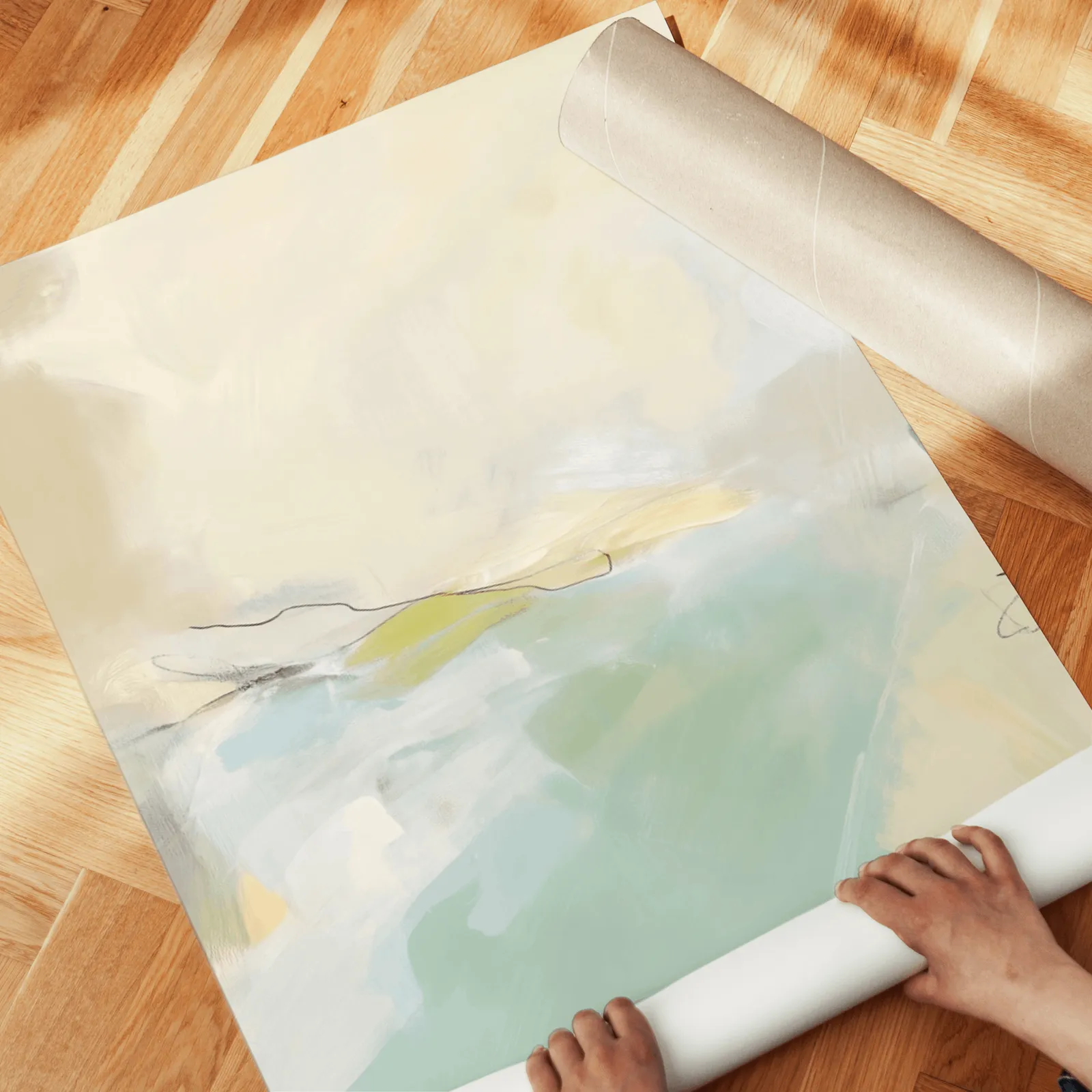 green and beige abstract wall art set of 3, unrolled across a herringbone wood floor by hand