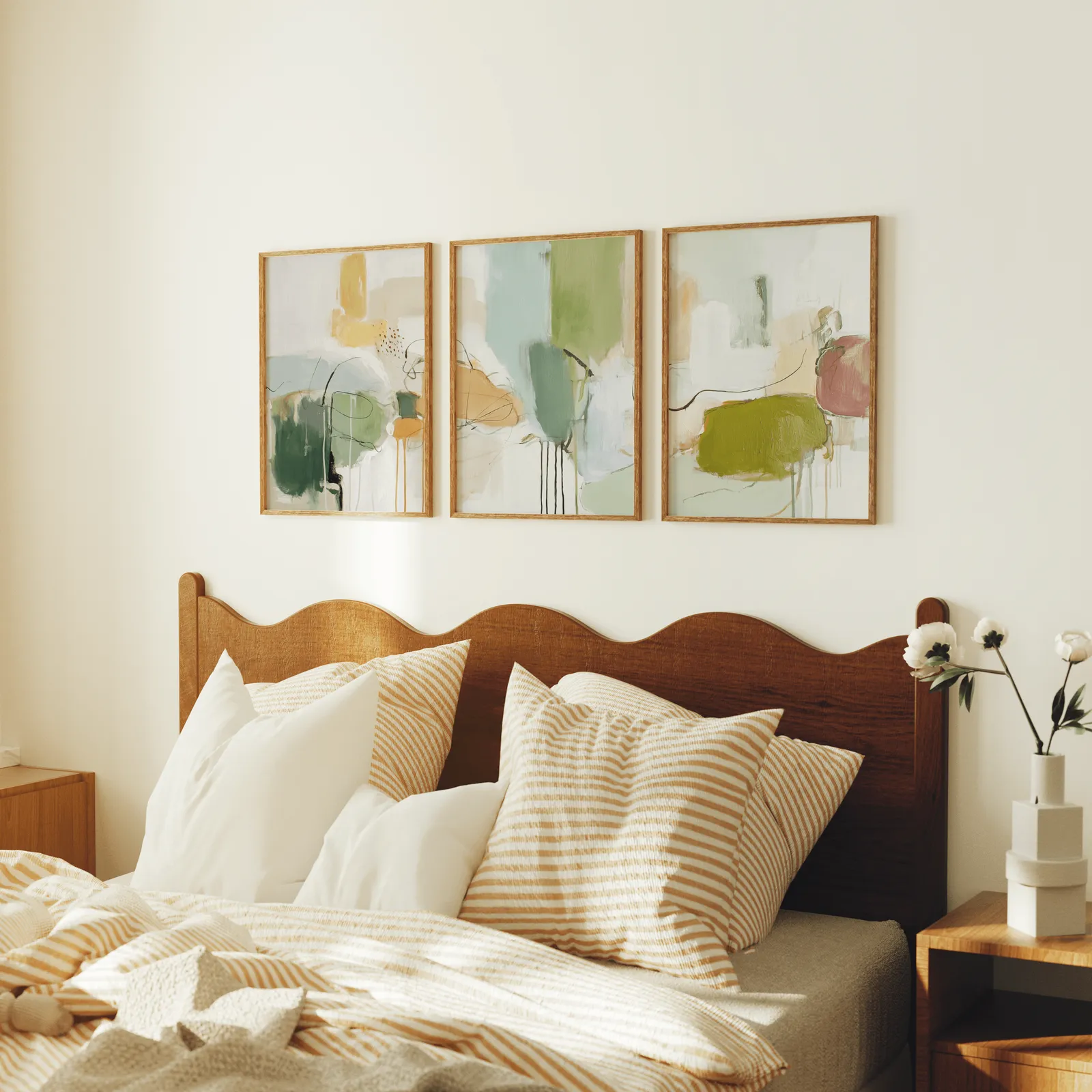 green abstract set of 3 wall art panels, above a scalloped wooden headboard with striped pillows