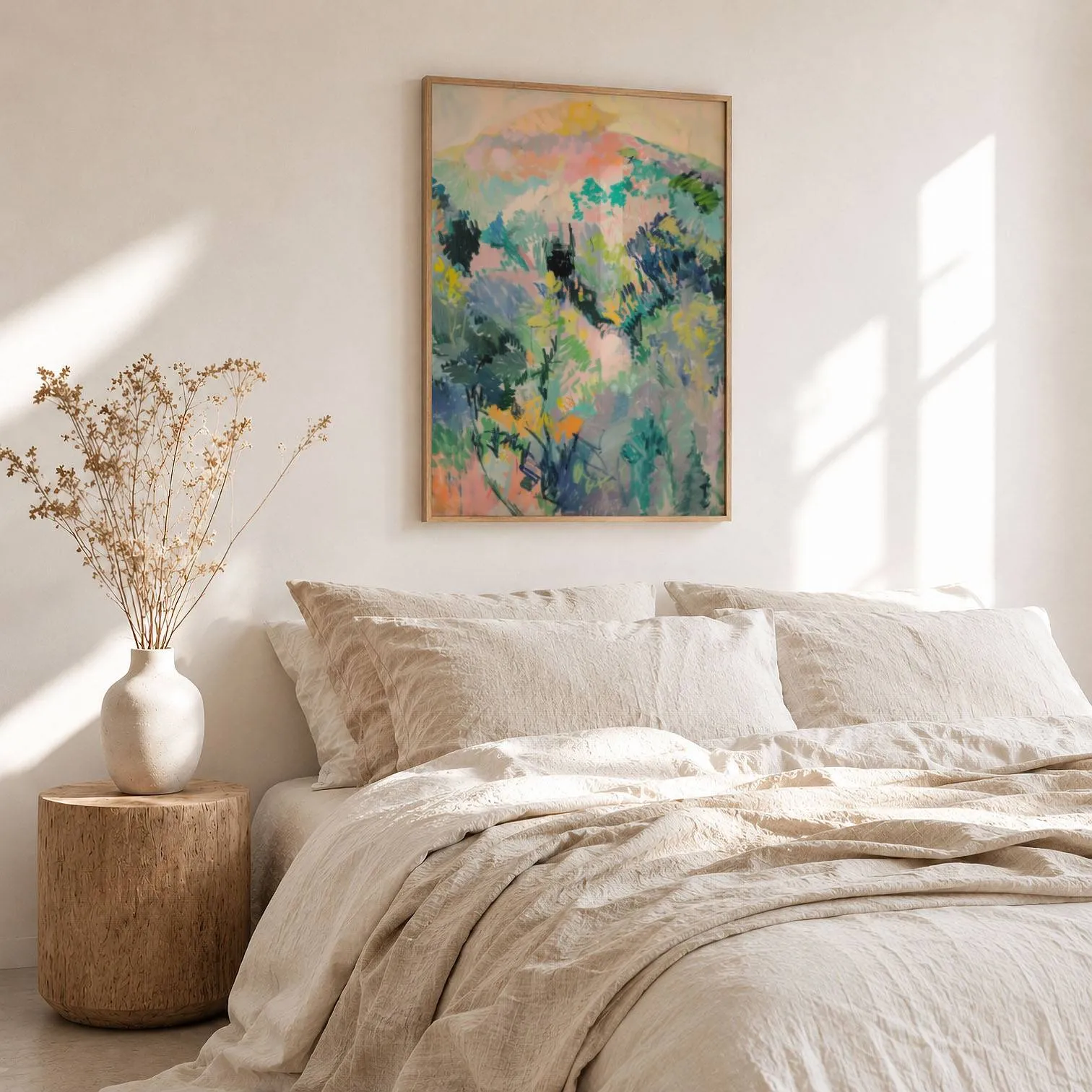 colorful landscape wall art of hillside foliage, above a rumpled linen bed beside a stump side table