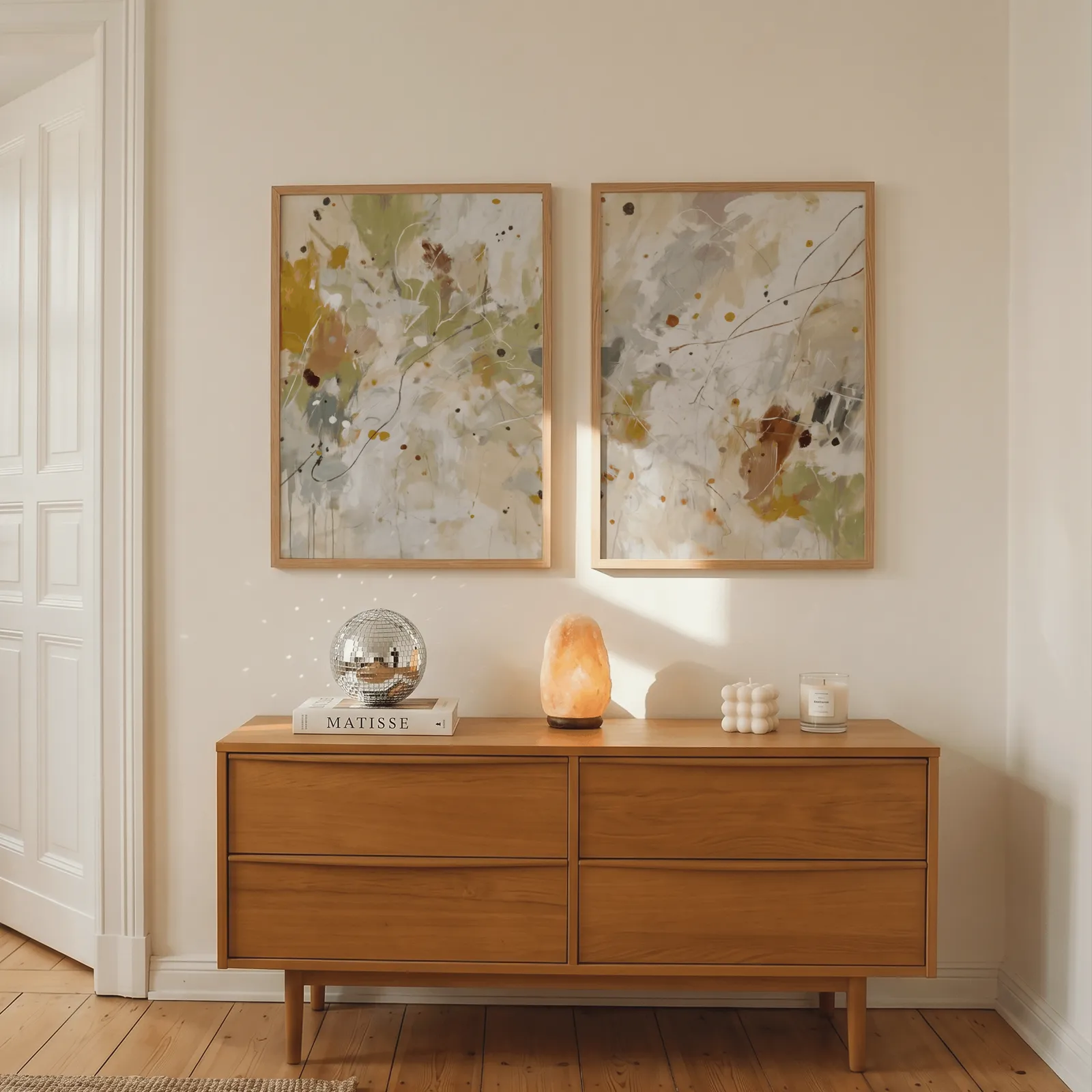 colorful abstract wall art set of two, above a wooden dresser with a salt lamp and disco ball