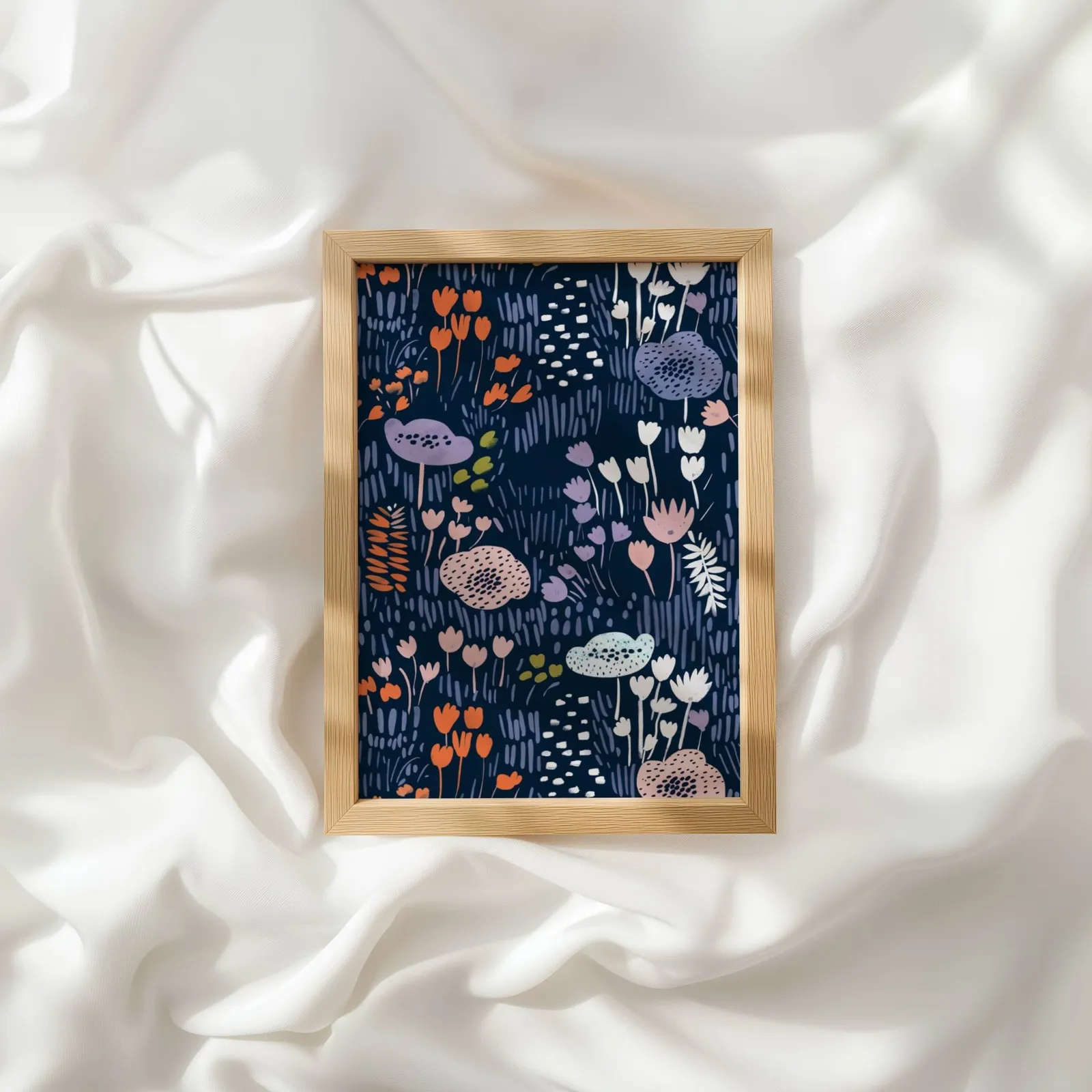 navy floral botanical wall art print, resting atop rumpled white silky fabric