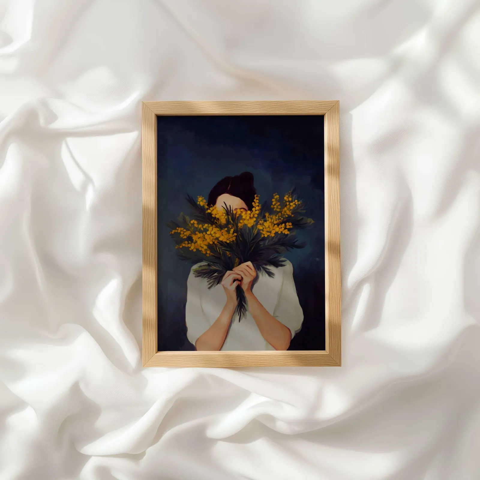woman with yellow mimosa flowers wall art, resting atop rumpled white silky fabric