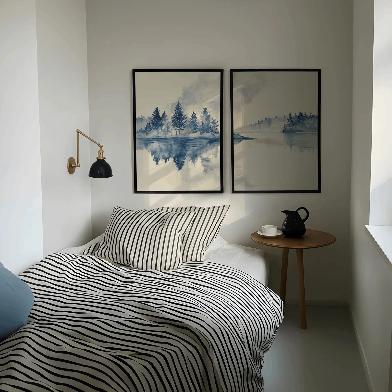 blue misty forest lake wall art set of 2, above a striped bed beside a brass swing-arm lamp