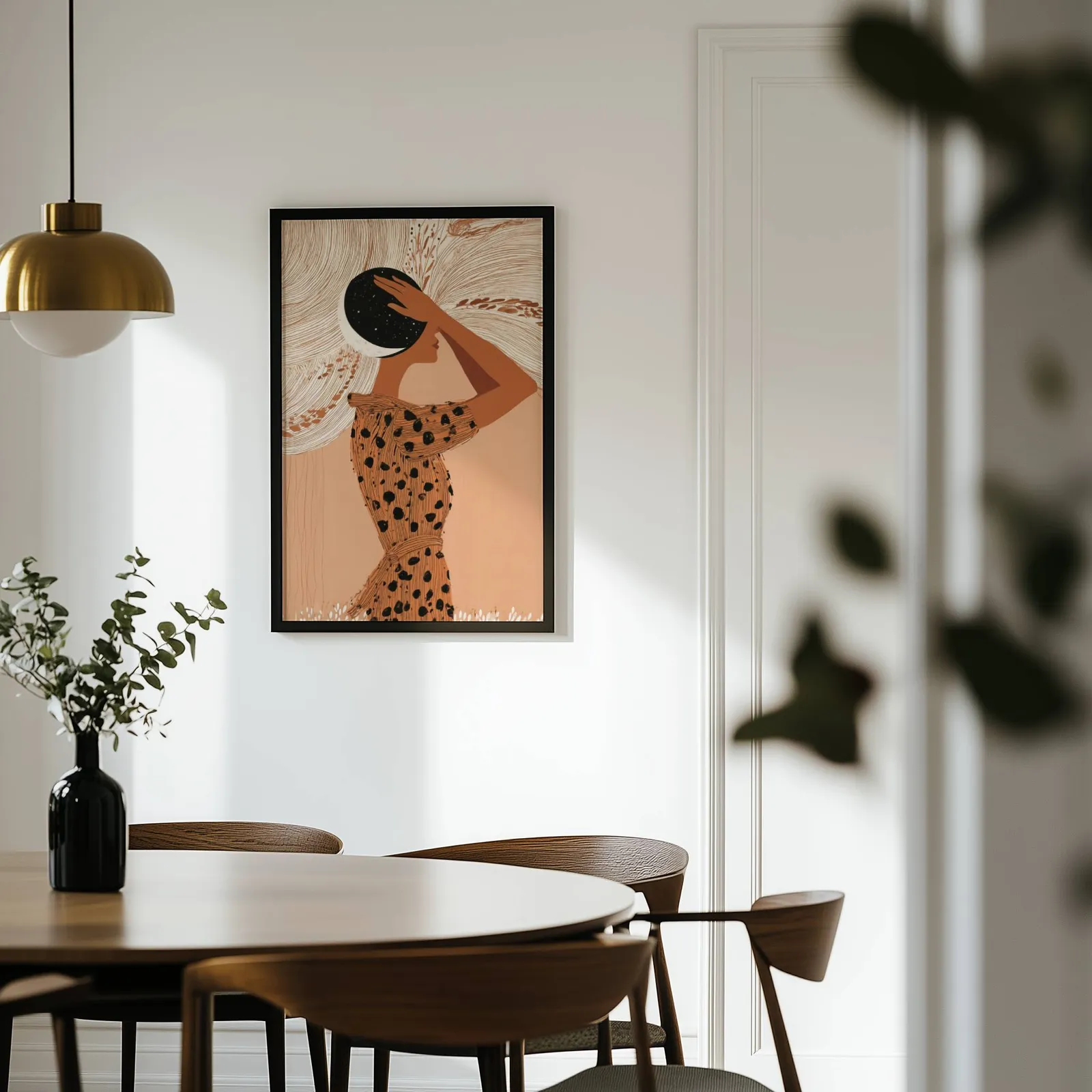 terracotta boho woman with moon wall art, on a white wall above a round wooden dining table