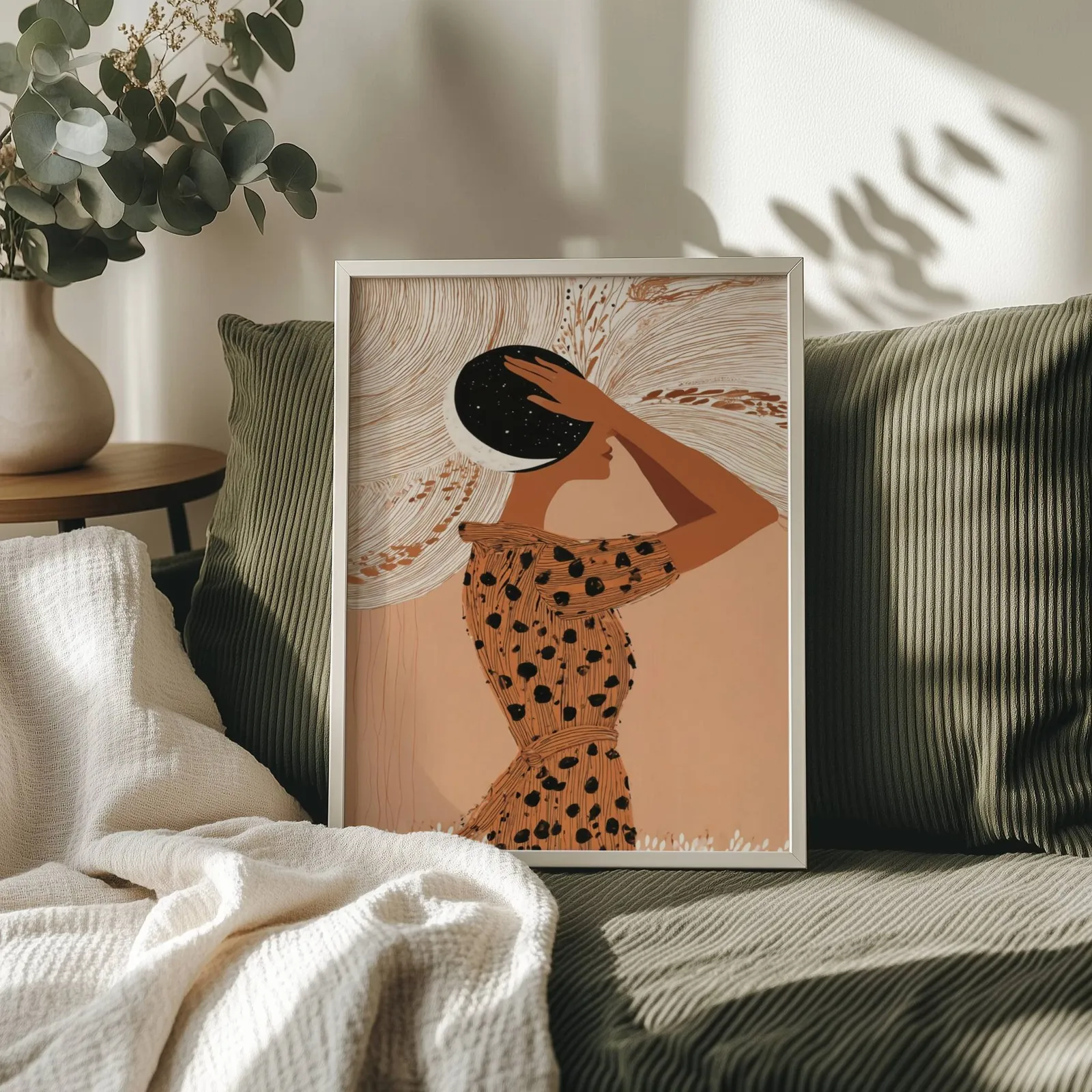 terracotta boho woman with moon wall art, propped on an olive corduroy sofa beside a eucalyptus vase