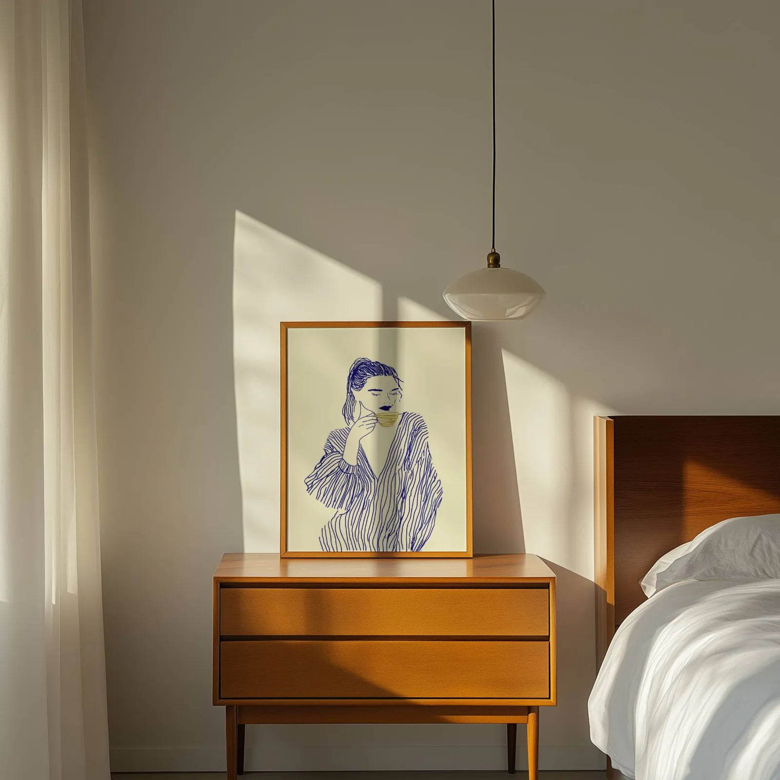 blue line art woman drinking coffee minimalist print, propped on a wooden dresser beside a pendant lamp