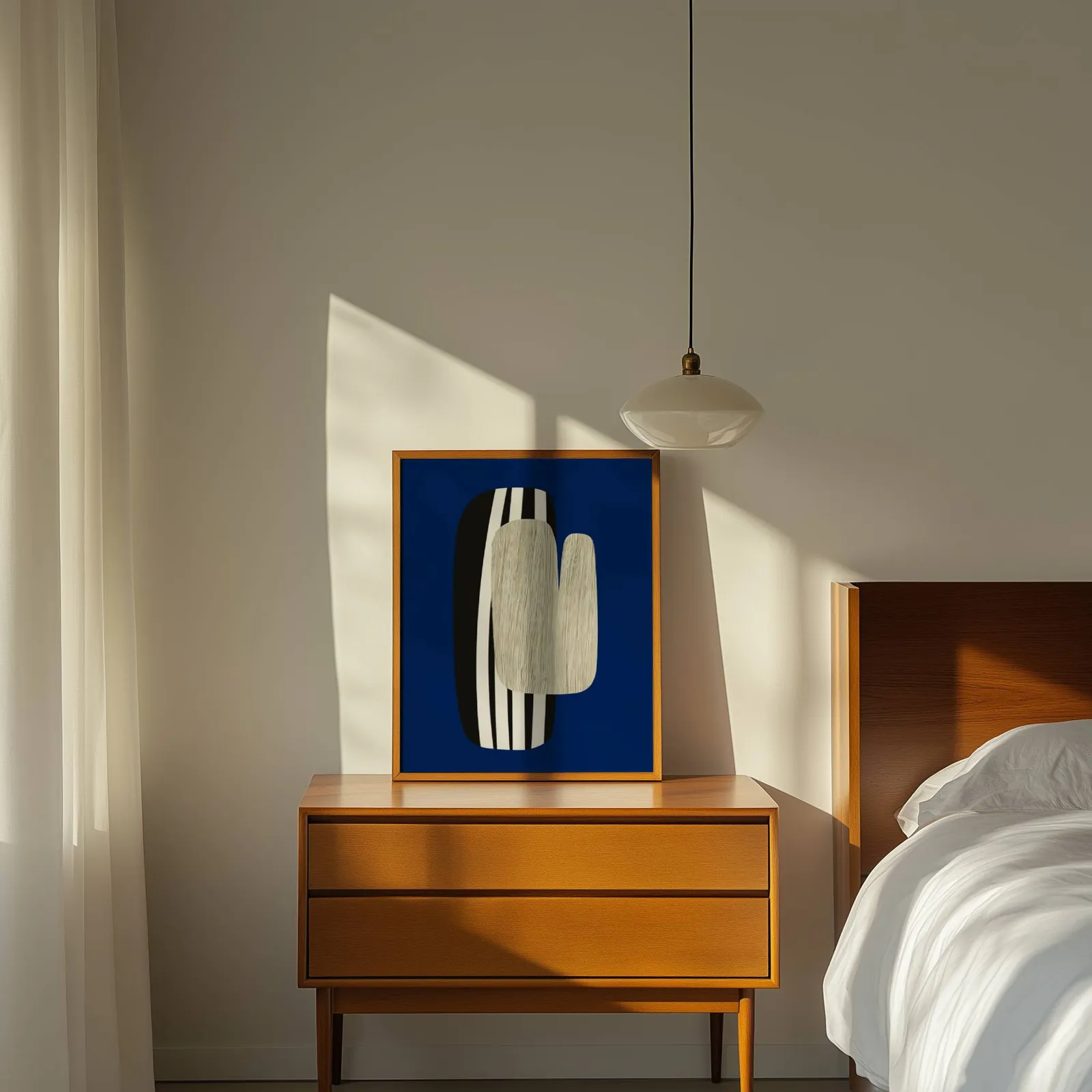 navy blue abstract wall art, propped on a wooden dresser beside a pendant lamp
