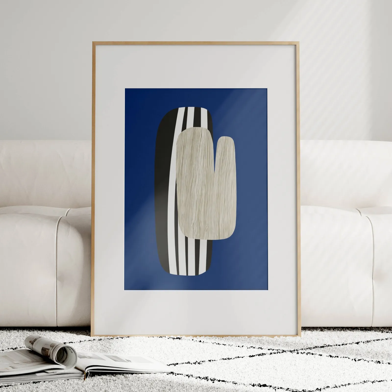 navy blue abstract wall art, leaning against a plush cream sofa on a patterned rug