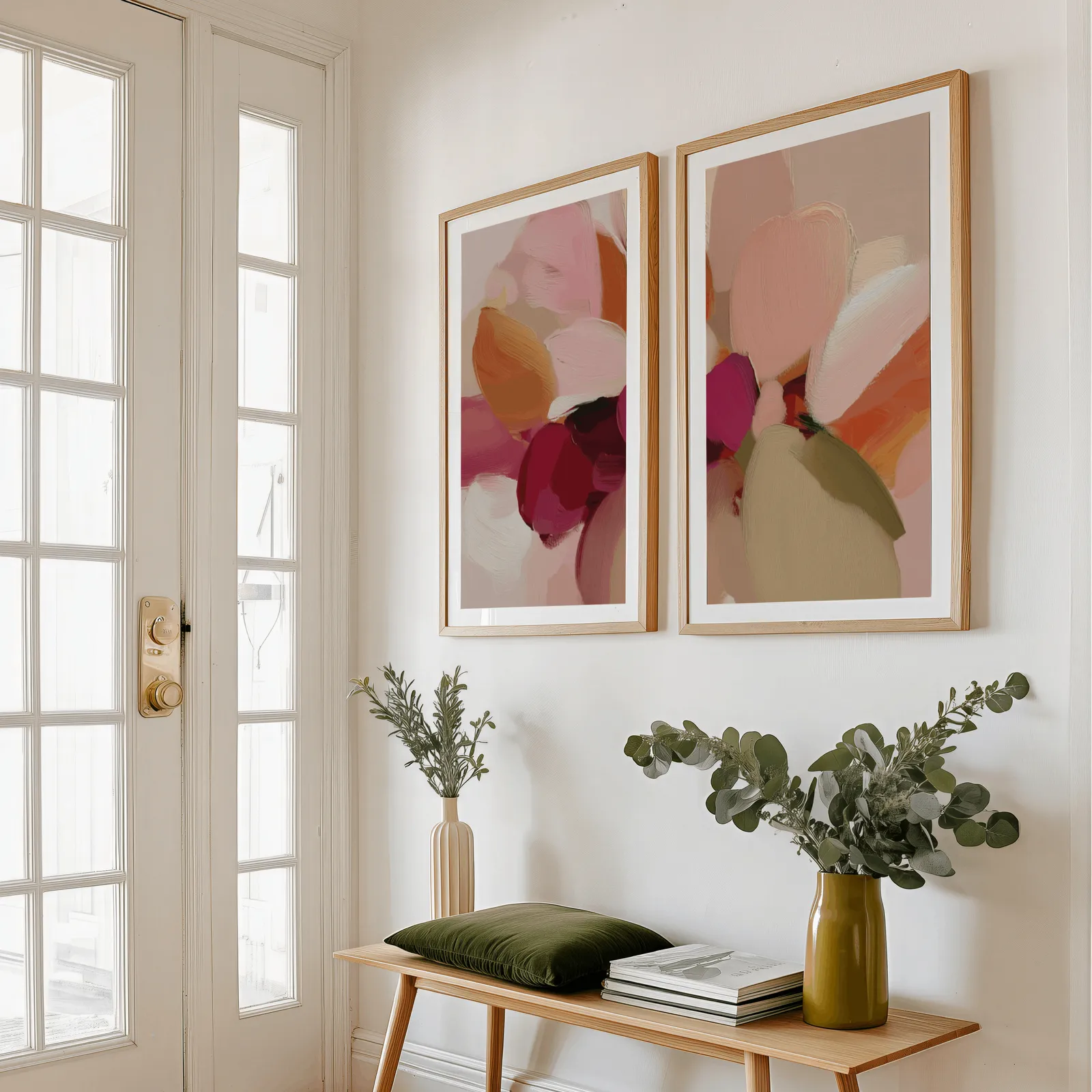 pink and orange abstract floral wall art set of 2, above a wooden bench with eucalyptus stems and a green cushion