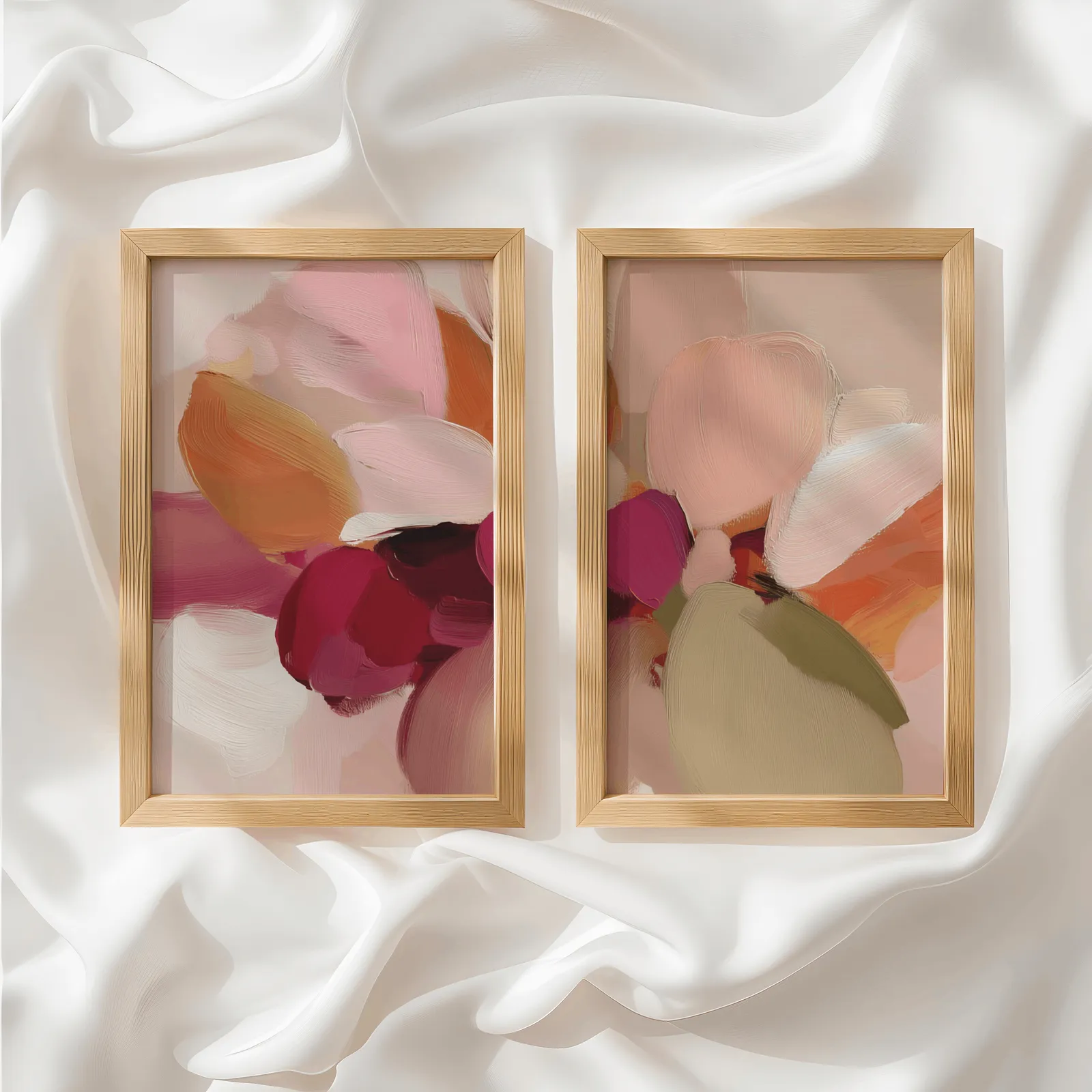 pink and orange abstract floral wall art set of 2, side by side atop rumpled white silky fabric