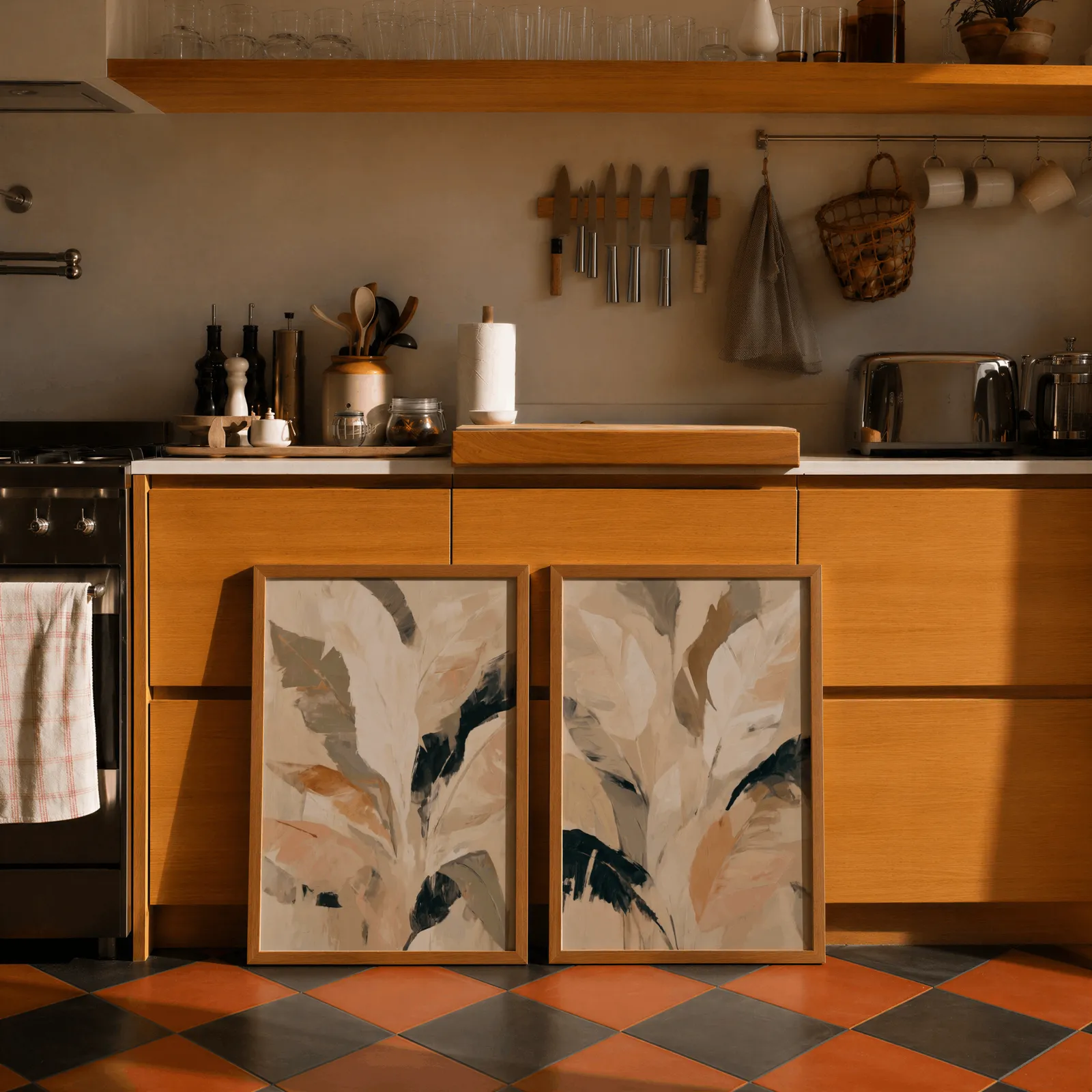 beige botanical leaves wall art set of 2, leaning against wooden cabinets on terracotta tiled floor