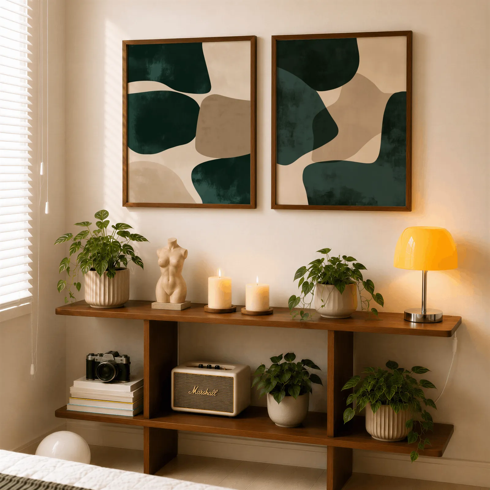 green and beige abstract wall art set of two, above a wooden console shelf with potted plants and a yellow lamp