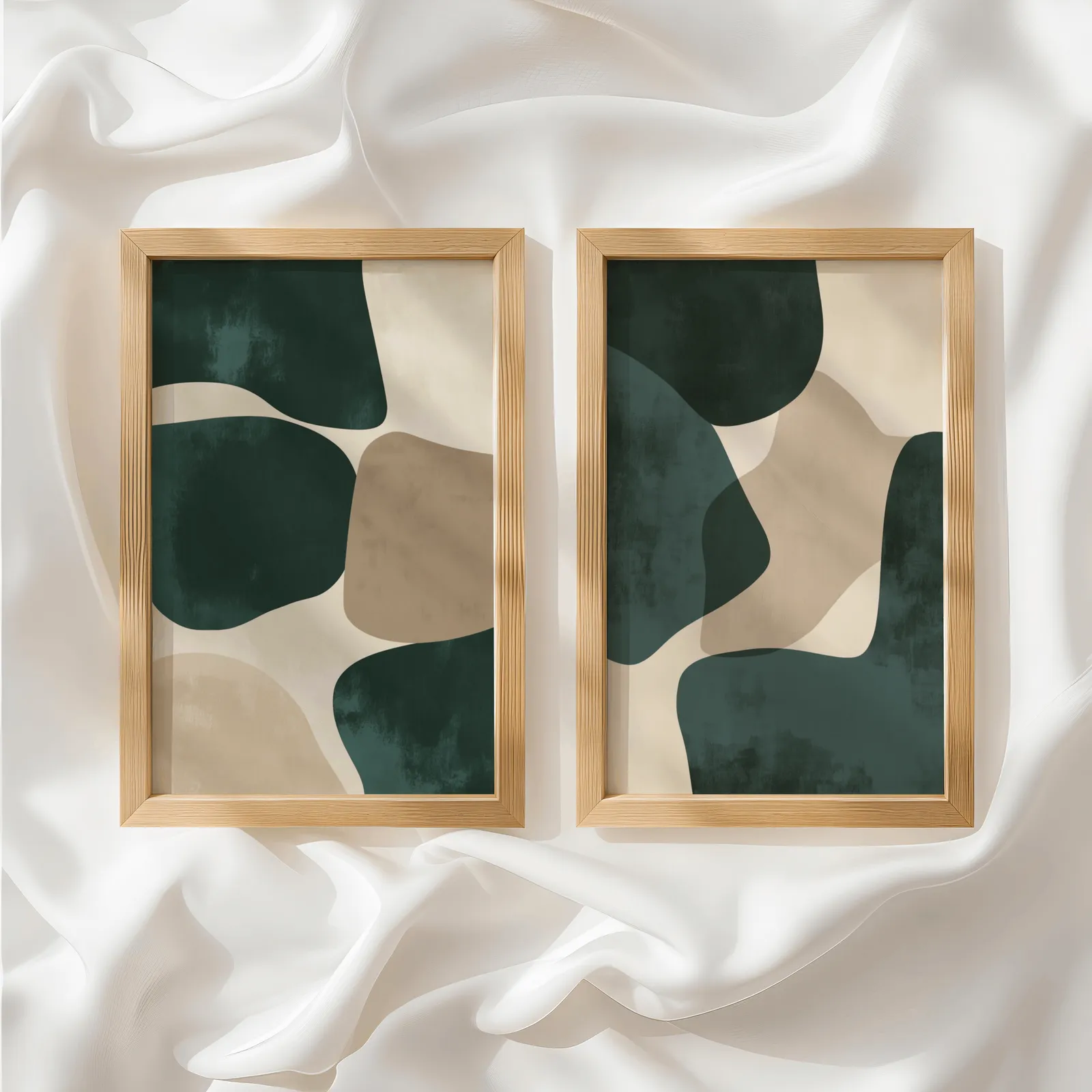 green and beige abstract wall art set of two, side by side atop rumpled white silky fabric