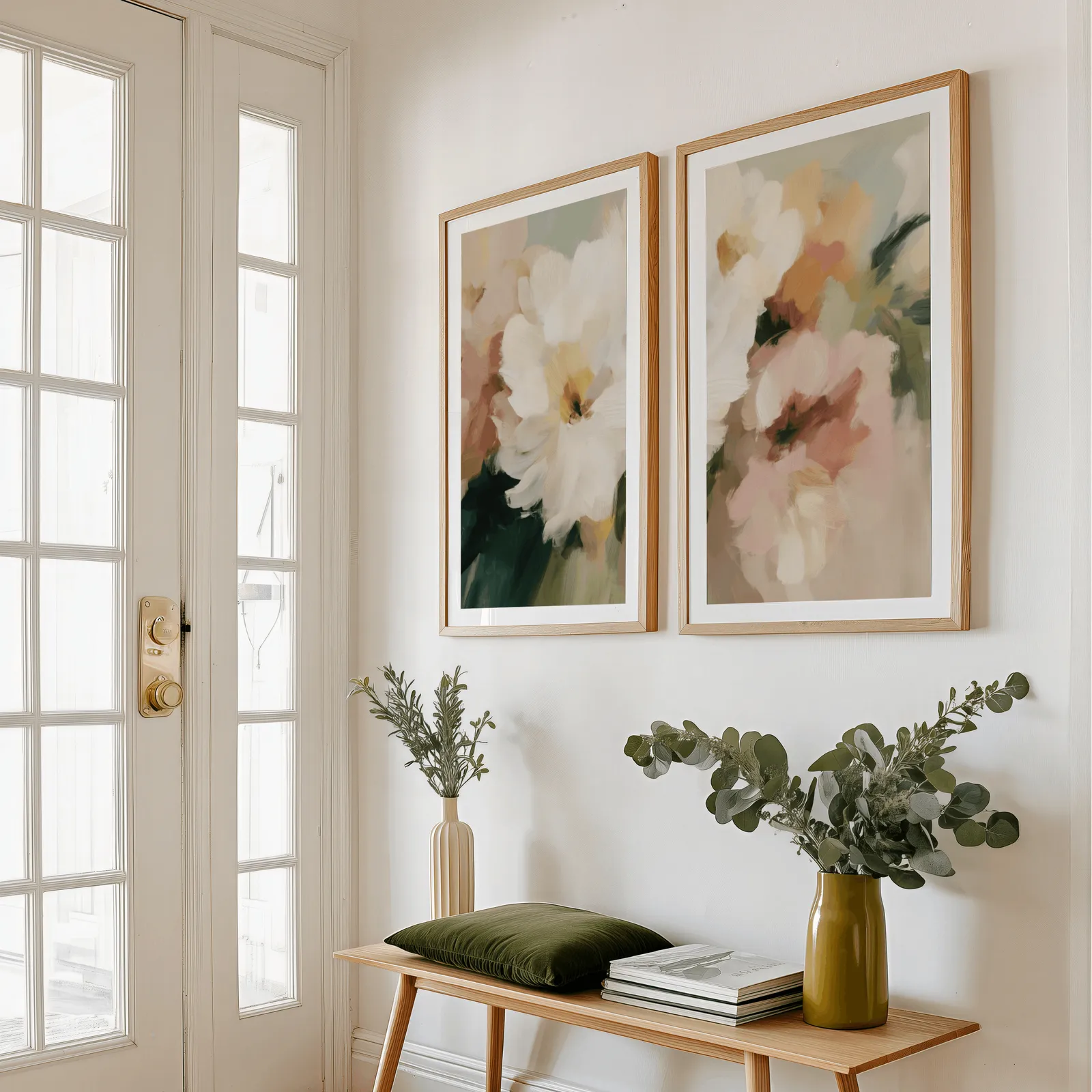 pink and cream floral wall art set of two, above a wooden bench with eucalyptus stems and a green cushion
