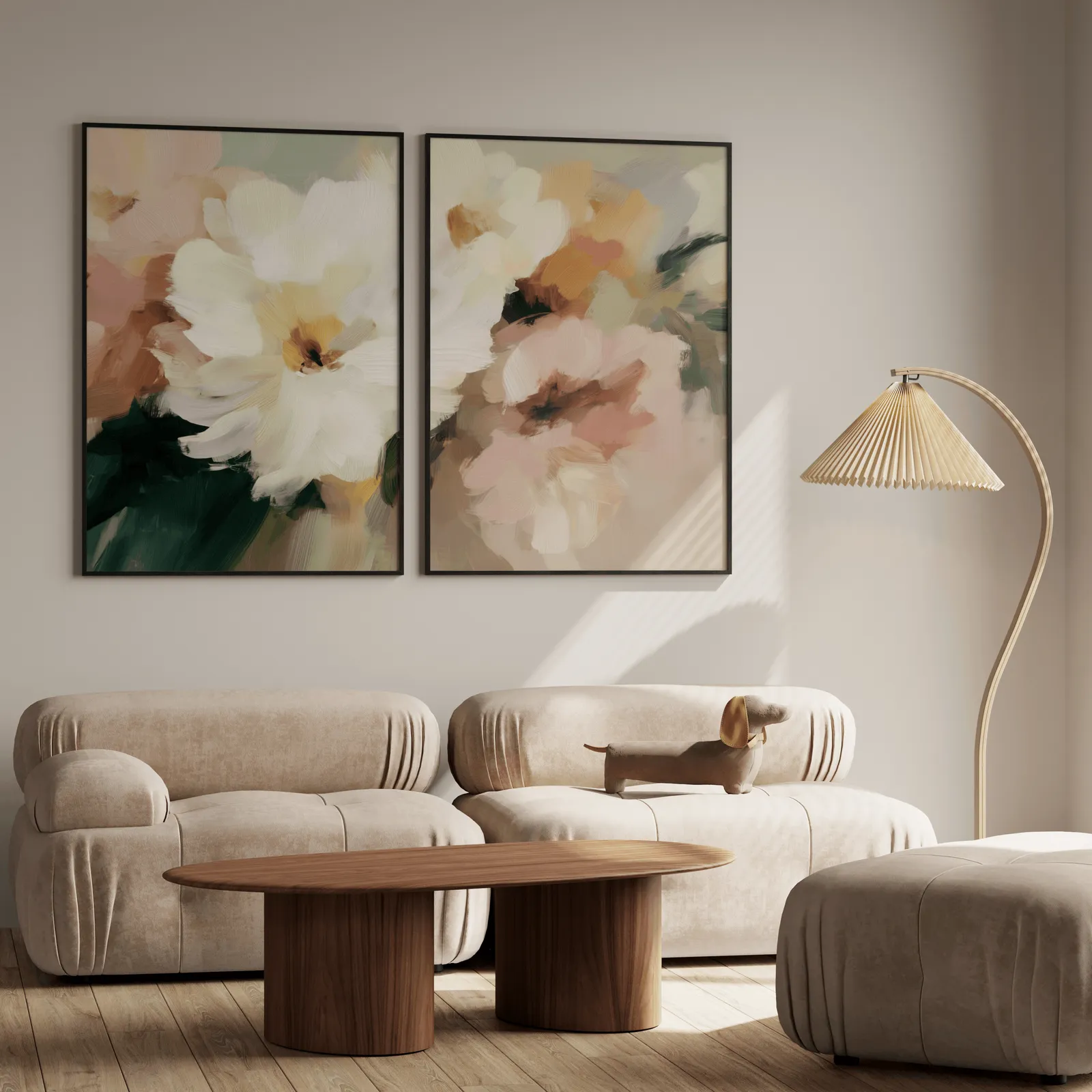 pink and cream floral wall art set of two, above a plush beige sofa with a pleated lamp nearby