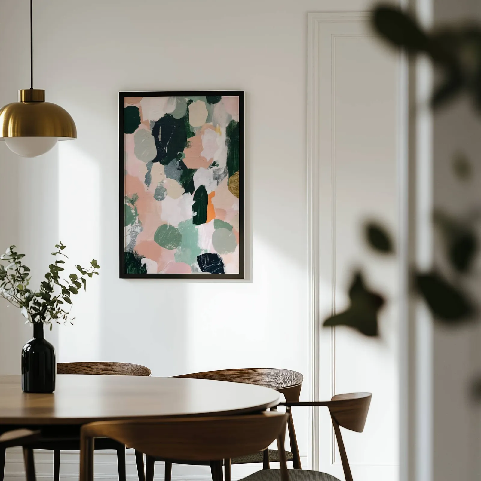 pink and green abstract floral wall art, on a white wall above a round wooden dining table