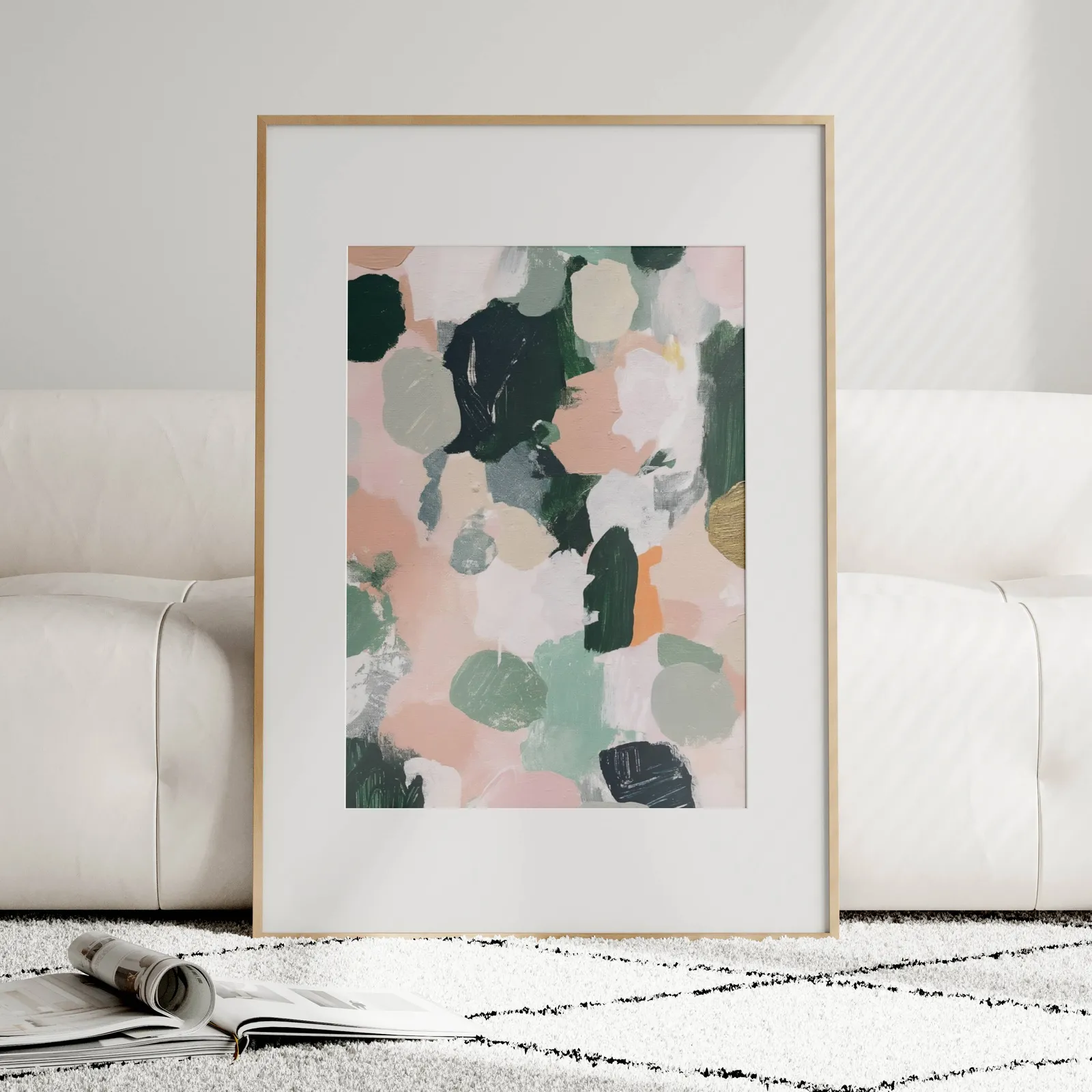 pink and green abstract floral wall art, leaning against a plush cream sofa on a patterned rug