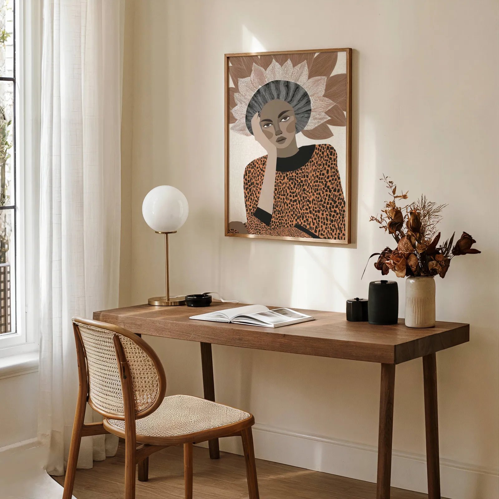 terracotta abstract woman portrait wall art with petal crown, above a wooden desk with a globe lamp and dried flowers