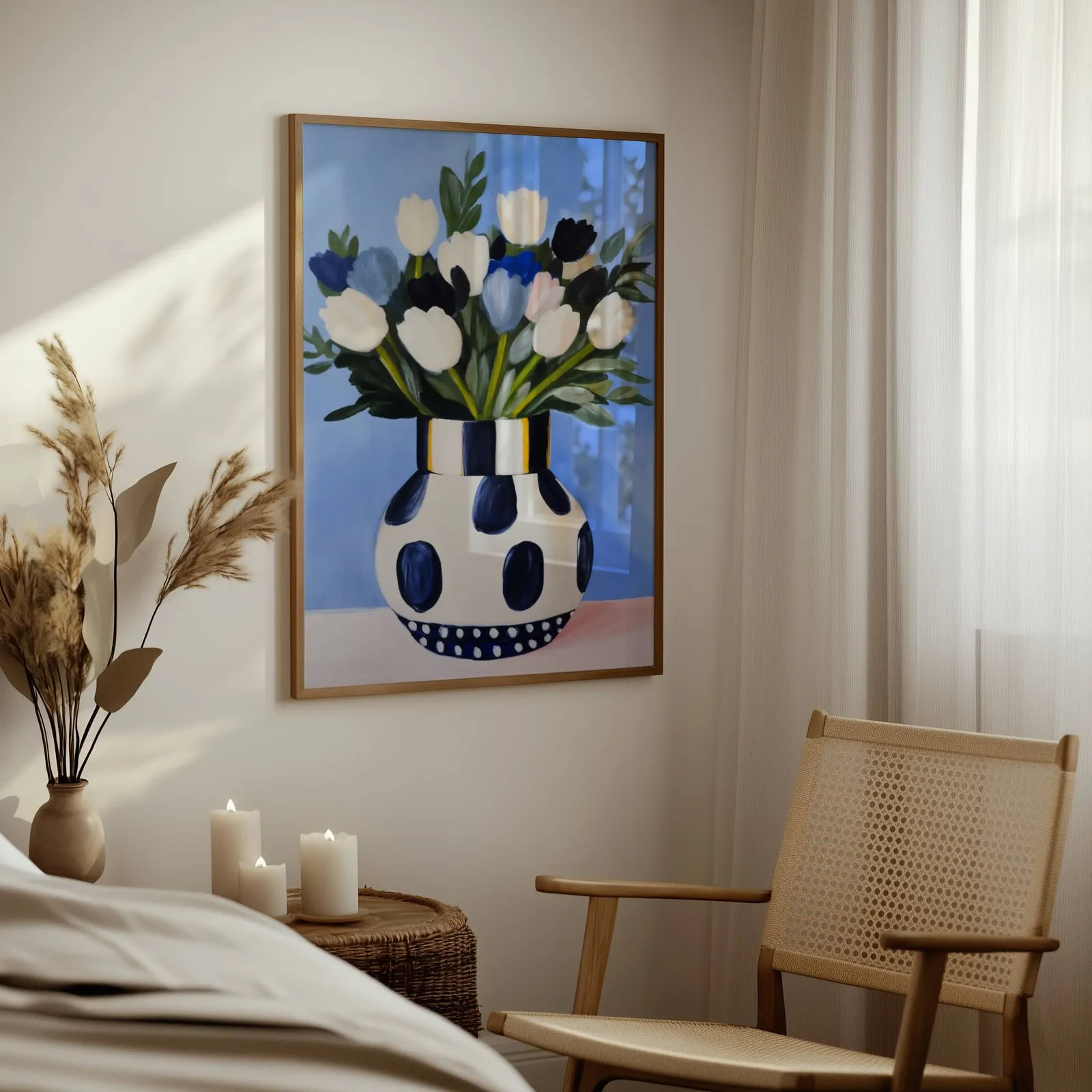 blue floral wall art with polka dot vase, above a woven side table with lit candles and pampas grass