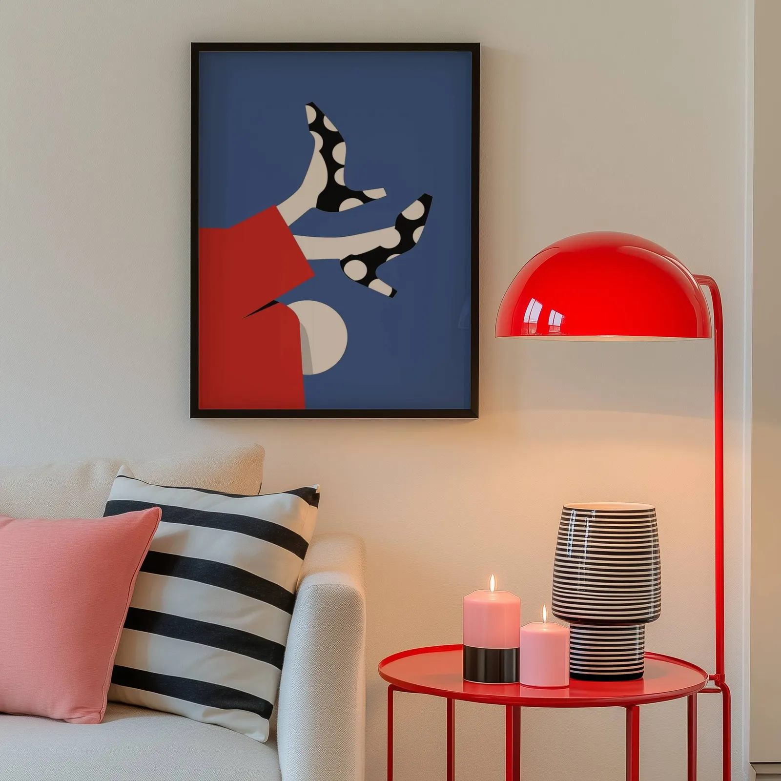 playful abstract woman wall art in red and blue, above a cream sofa beside a glossy red dome lamp
