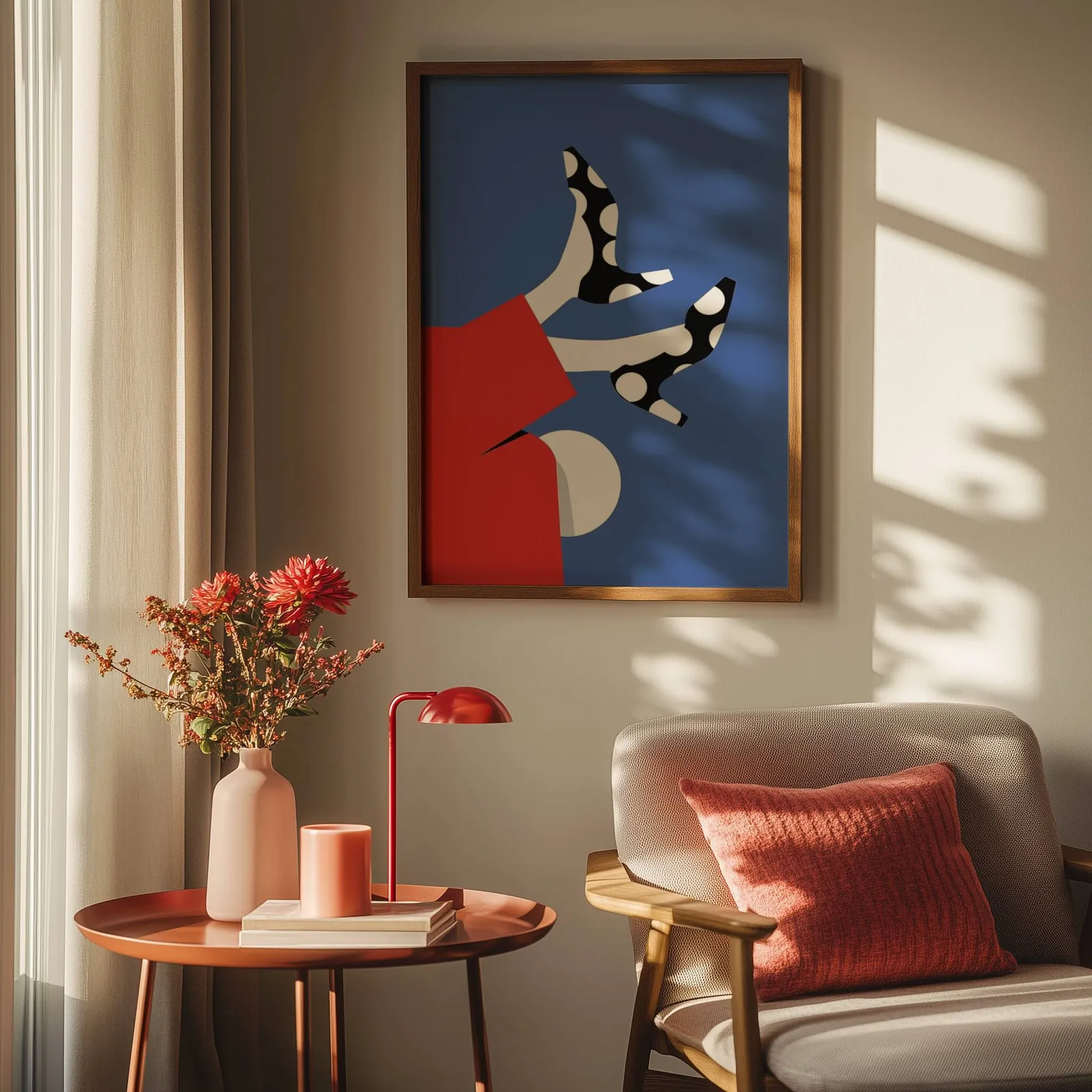 playful abstract woman wall art in red and blue, above a round side table with a red lamp and dahlias