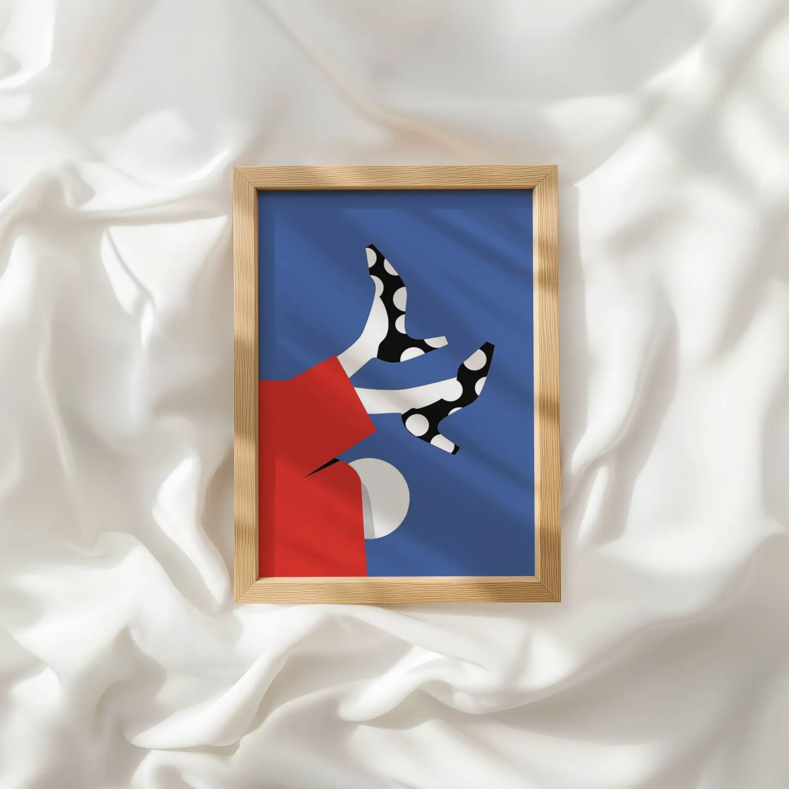 playful abstract woman wall art in red and blue, resting atop rumpled white silky fabric