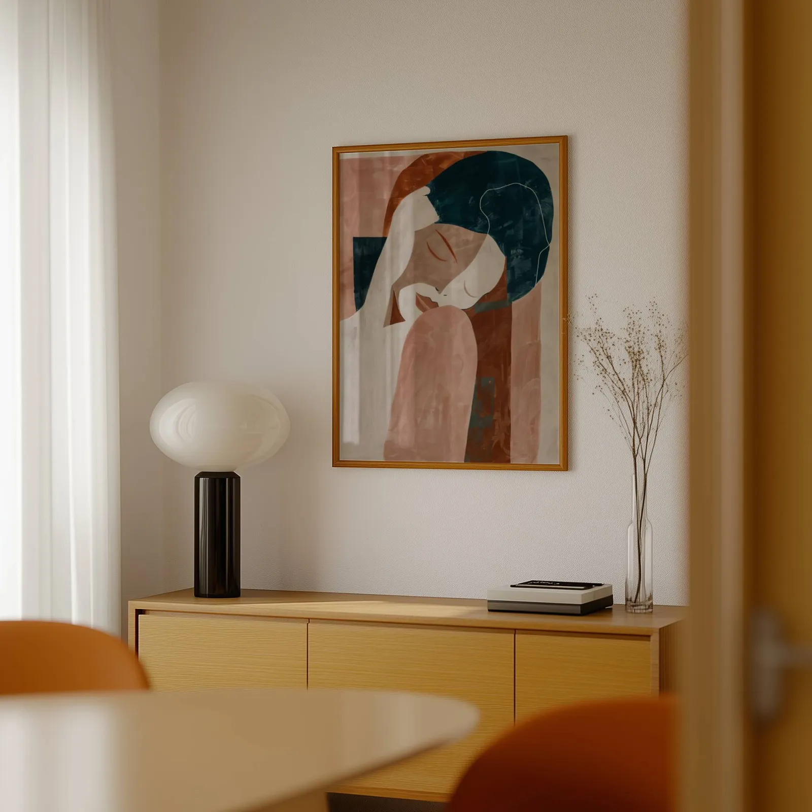 terracotta abstract woman wall art, above a light wood sideboard beside a bulbous black lamp