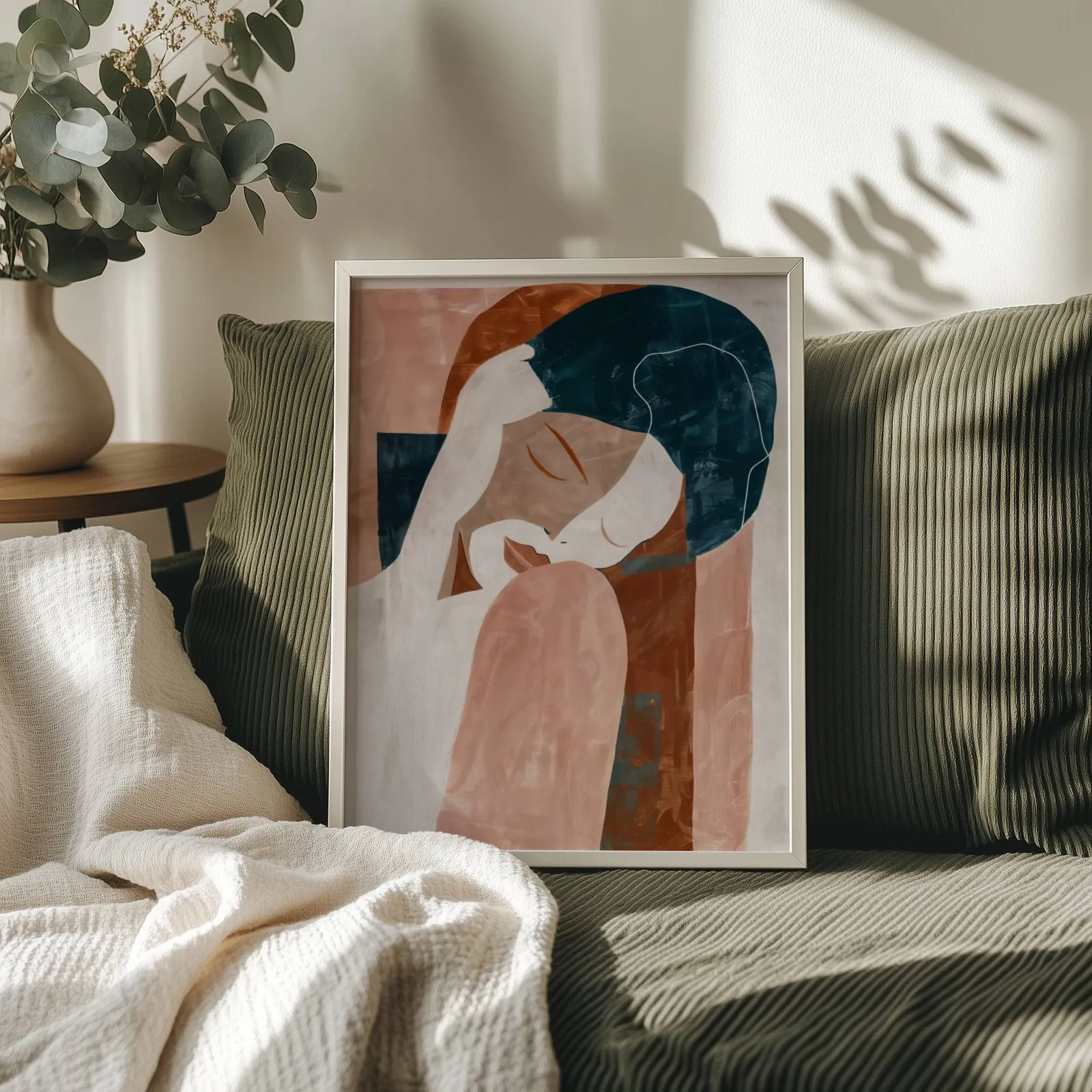 terracotta abstract woman wall art, propped on an olive corduroy sofa beside a eucalyptus vase