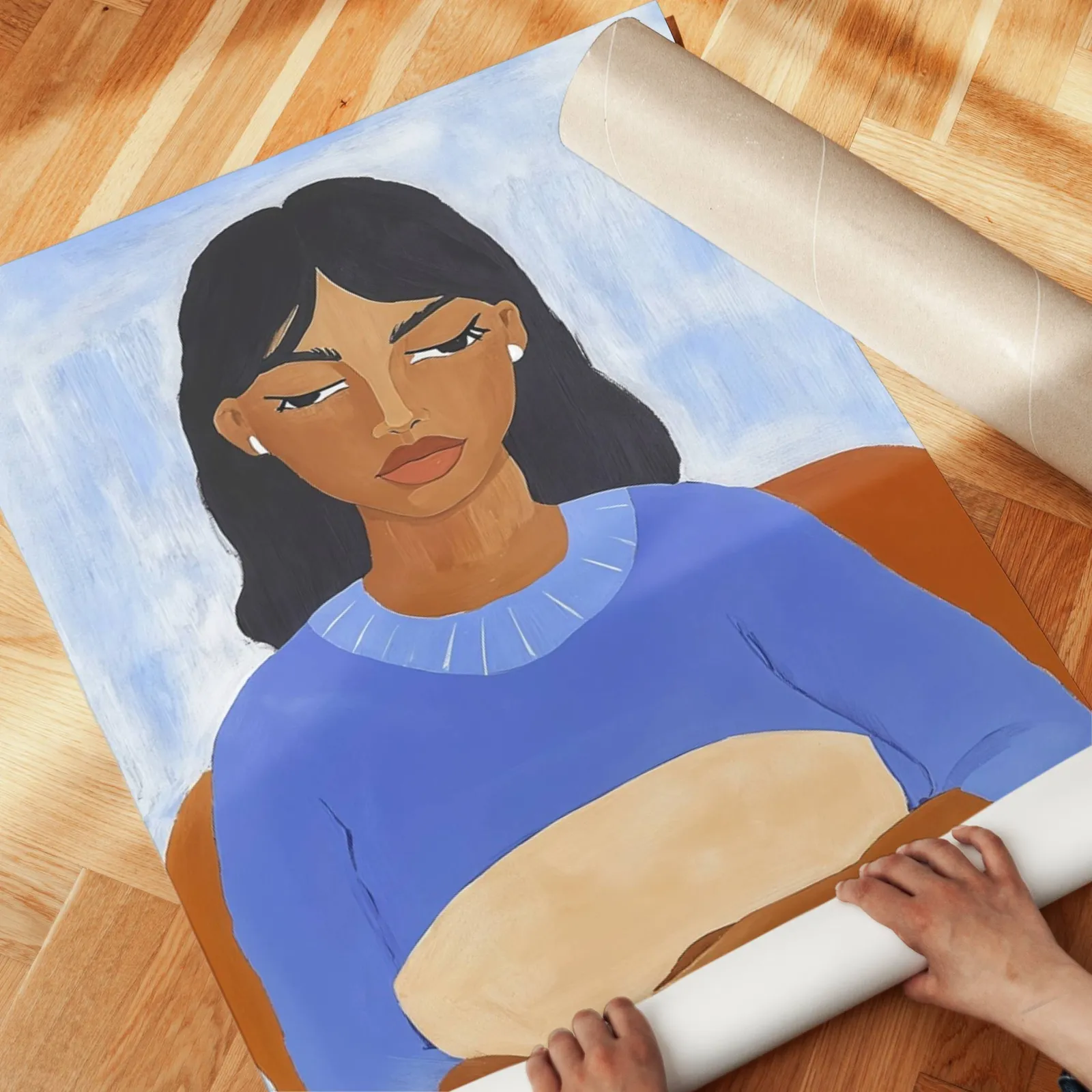 blue portrait wall art of seated woman, unrolled across a herringbone parquet floor by hand