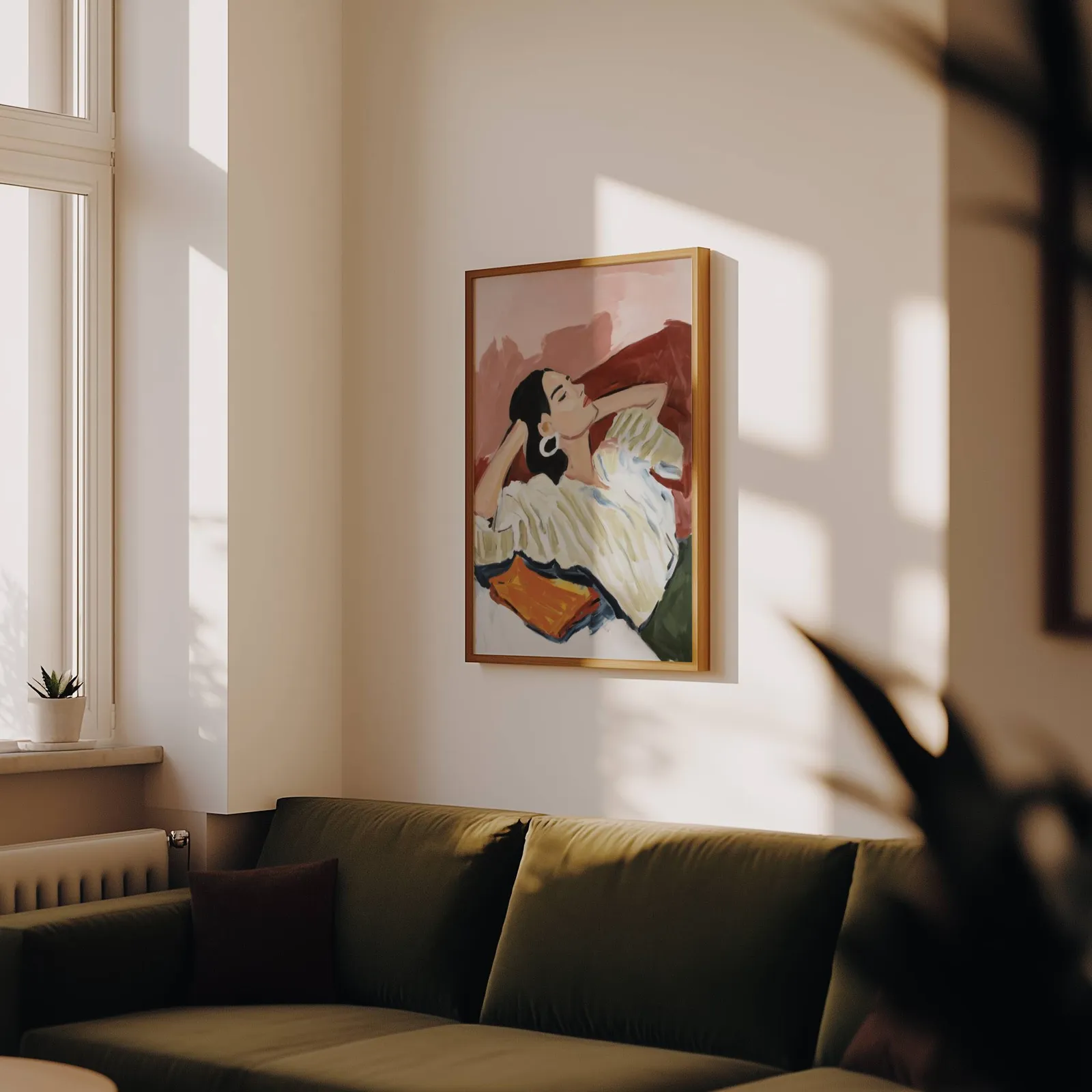 terracotta reclining woman portrait wall art, above an olive velvet sofa in raking afternoon light
