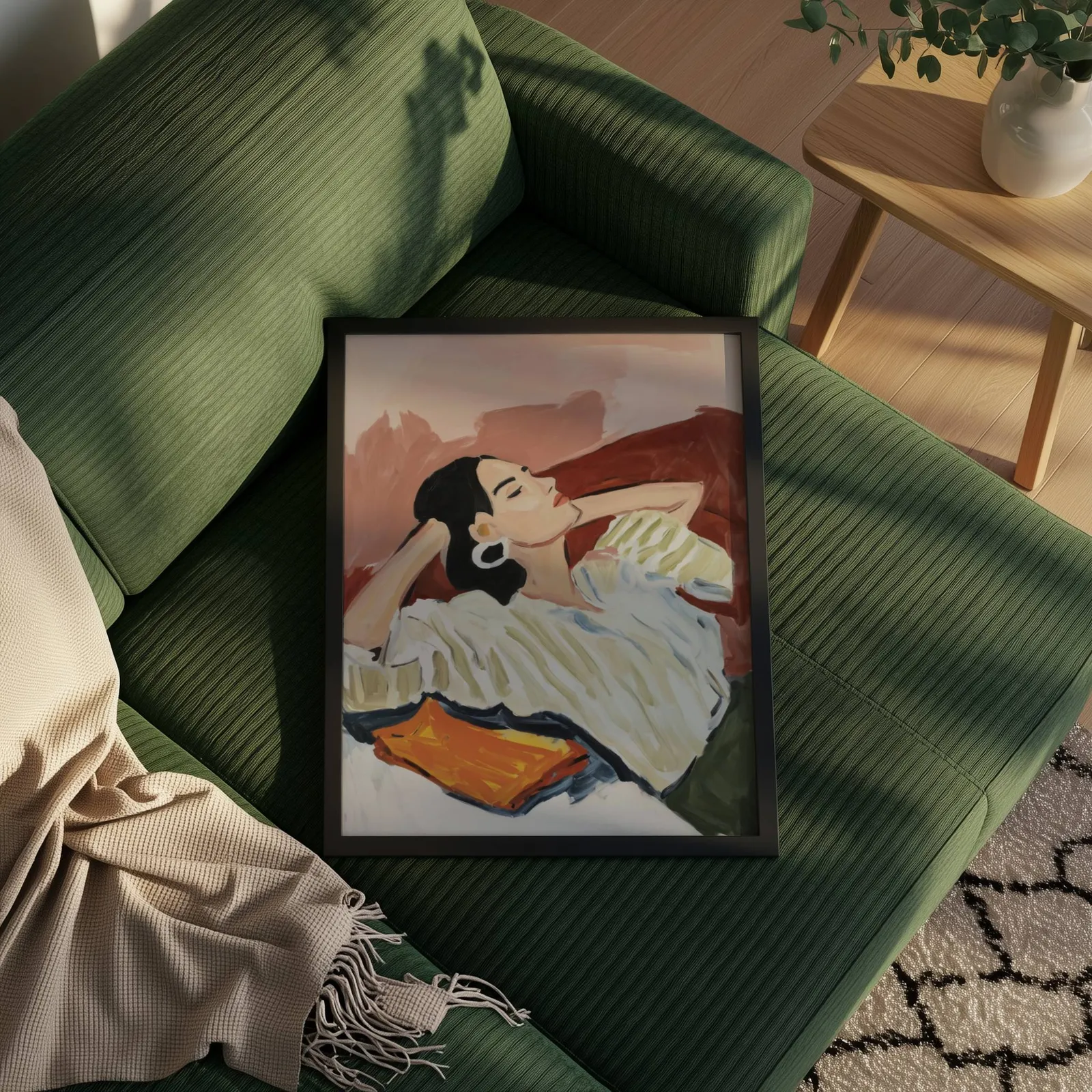 terracotta reclining woman portrait wall art, propped on a ribbed olive-green sofa beside a fringed throw
