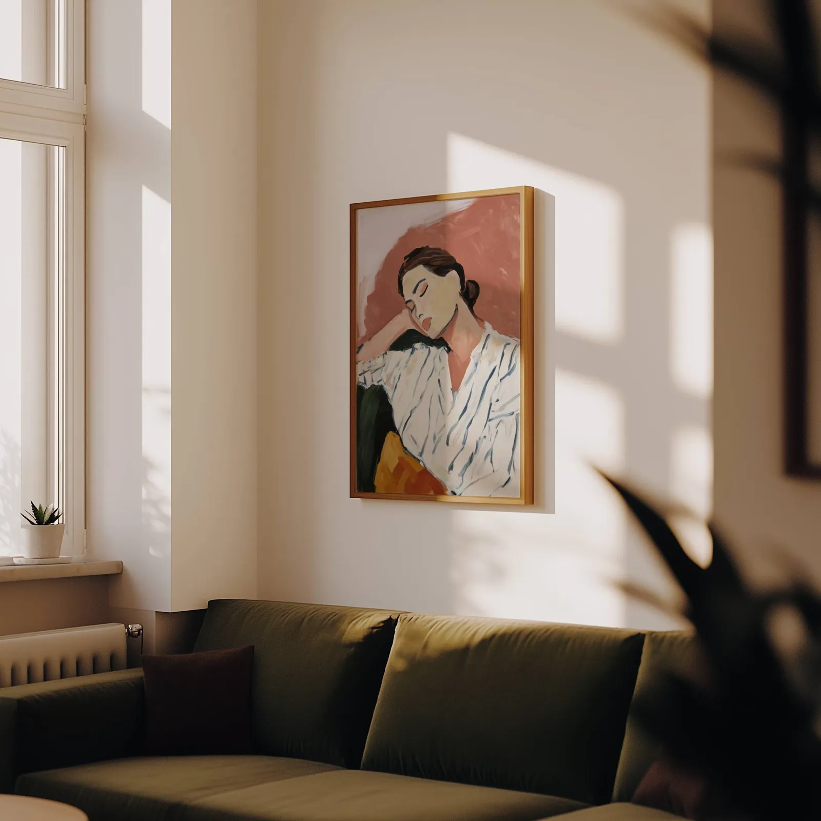 terracotta abstract portrait wall art of resting woman, above an olive velvet sofa in raking afternoon light