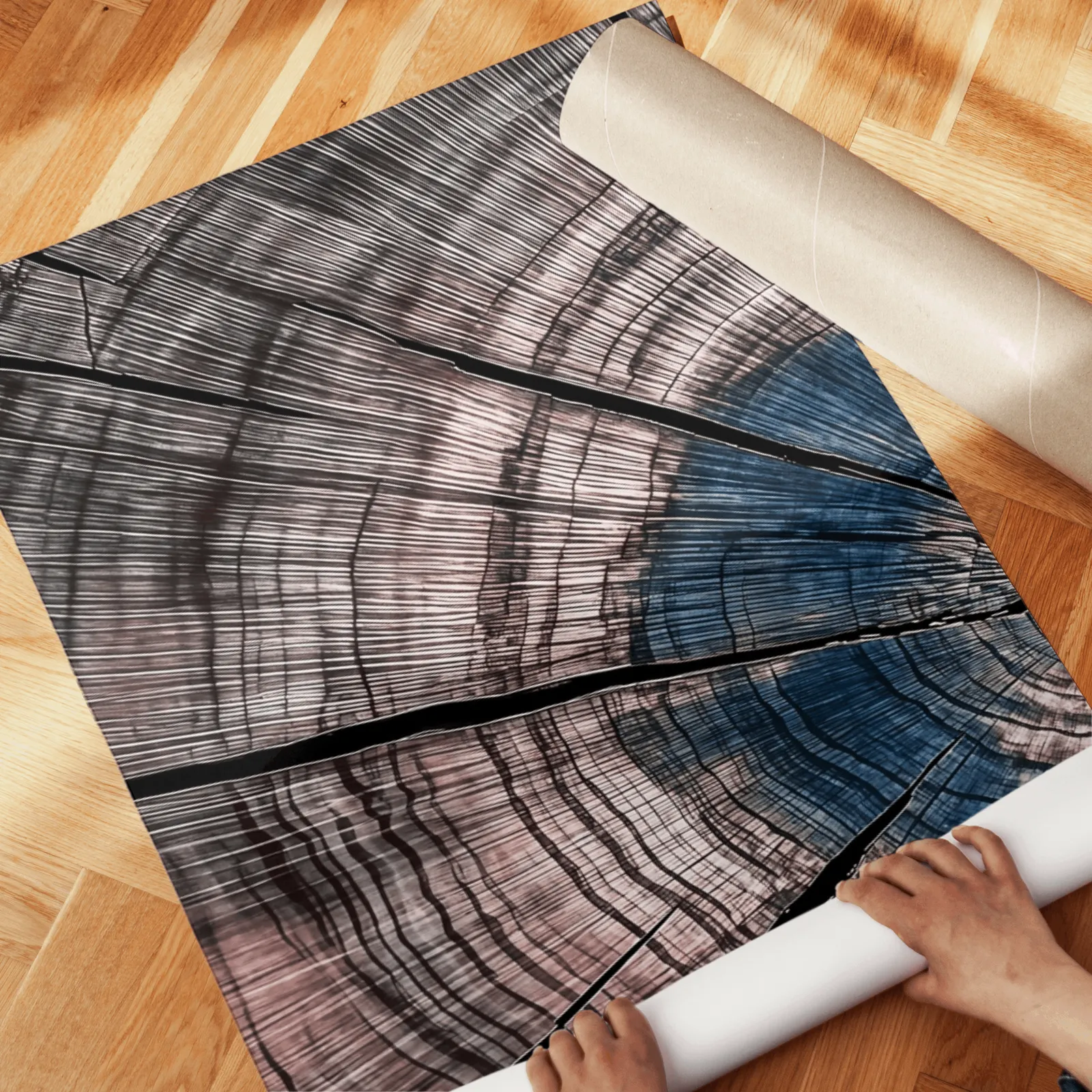 blue and pink tree rings triptych wall art, unrolled across a herringbone wood floor by hand