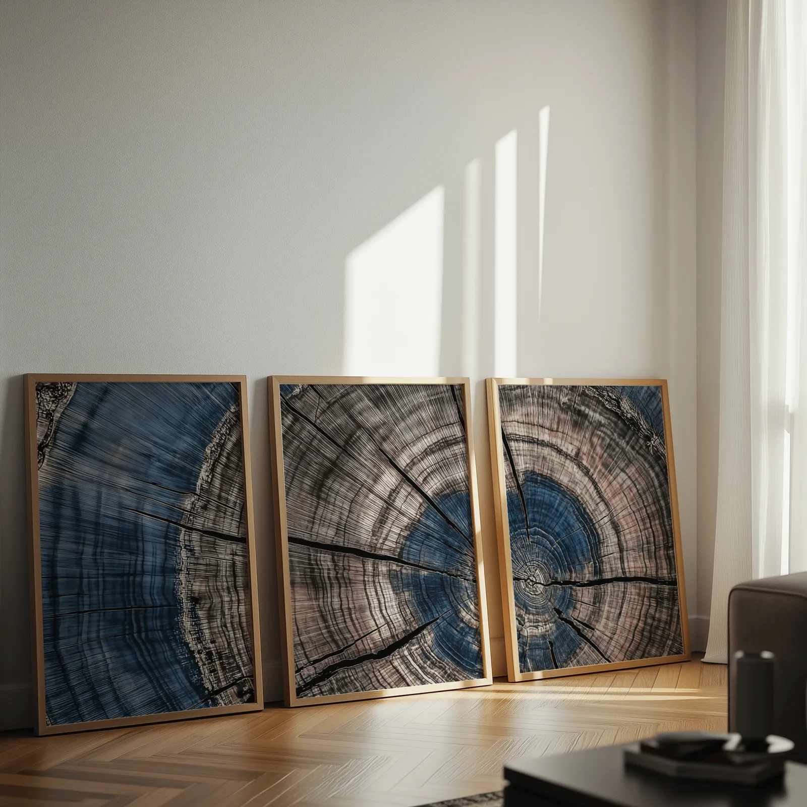 blue and pink tree rings triptych wall art, leaning against a sunlit wall on herringbone flooring