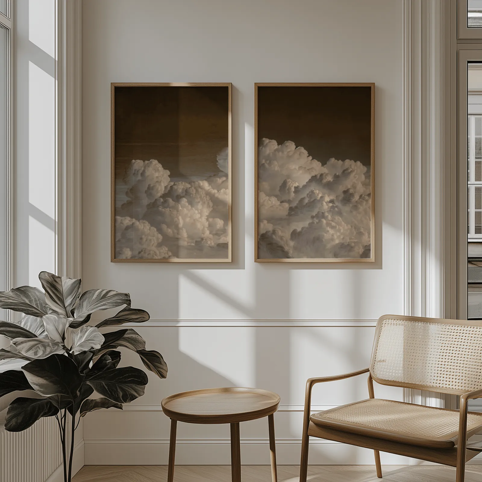 moody cloud landscape wall art set of 2, above wainscoting beside a cane armchair and fiddle-leaf fig