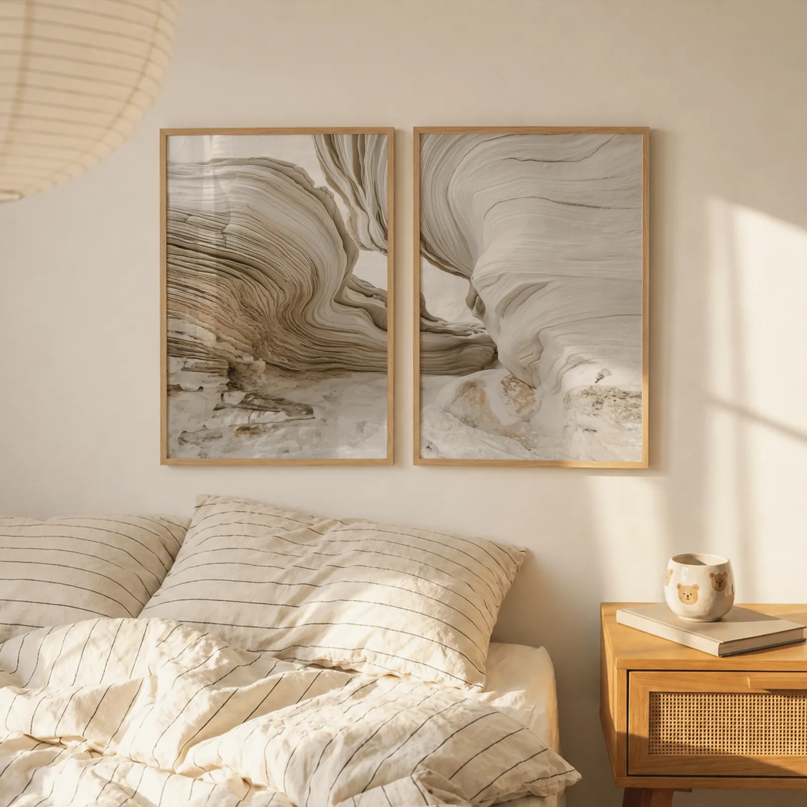 beige abstract stone texture wall art set of 2, above a striped linen bed beside a paper lantern shade