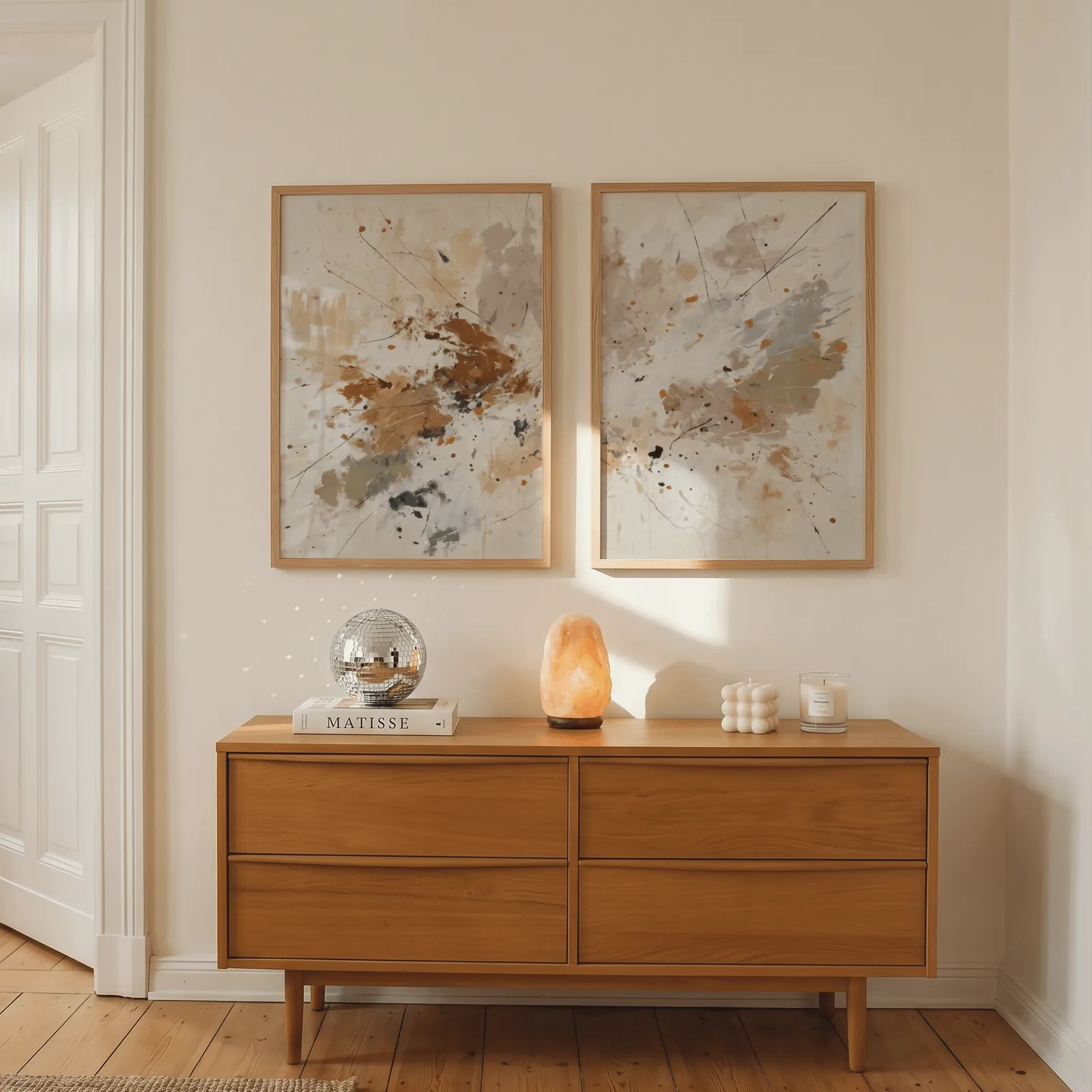 terracotta abstract wall art set of two, above a wooden dresser with a salt lamp and disco ball