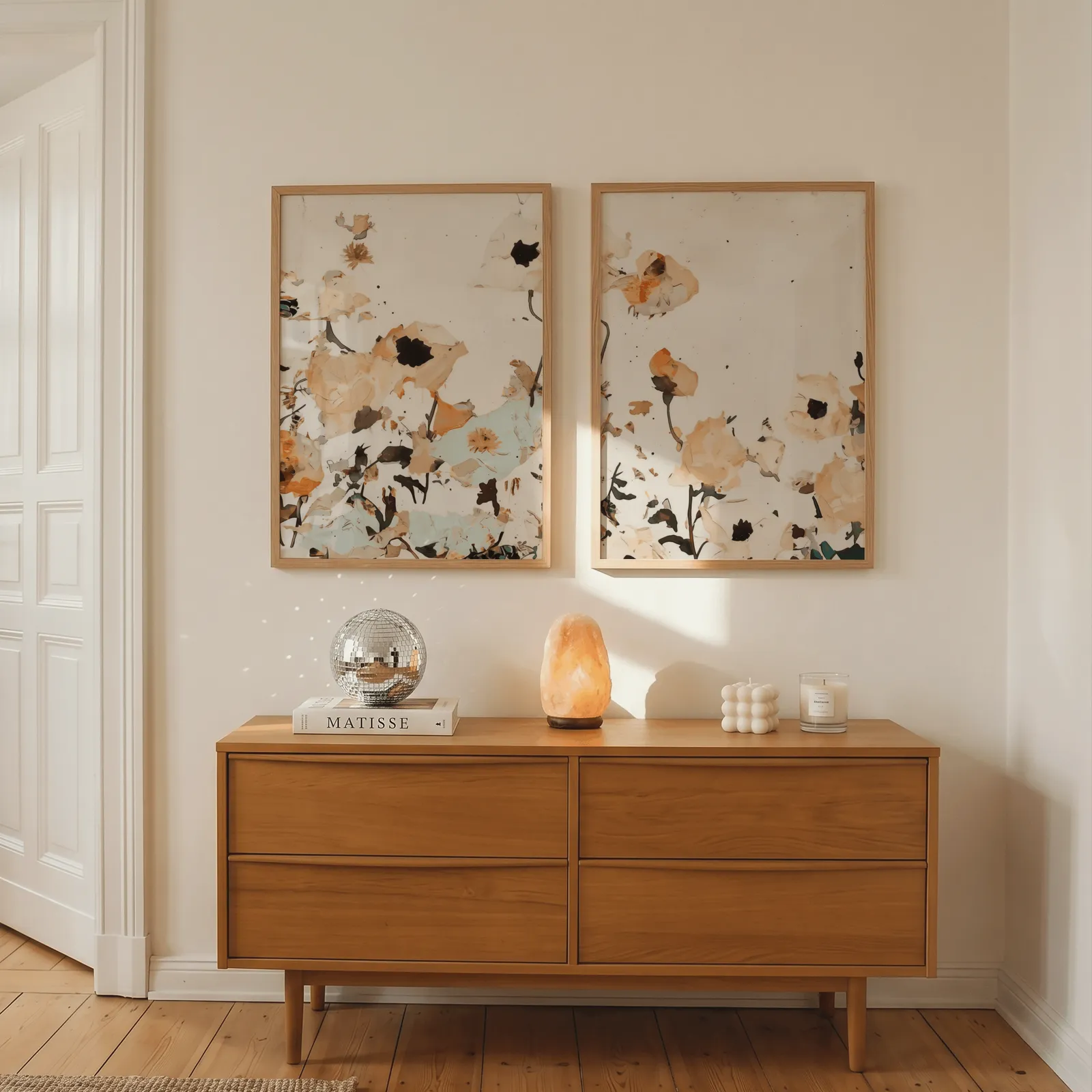 orange abstract floral wall art set of two, above a wooden dresser with a salt lamp and disco ball
