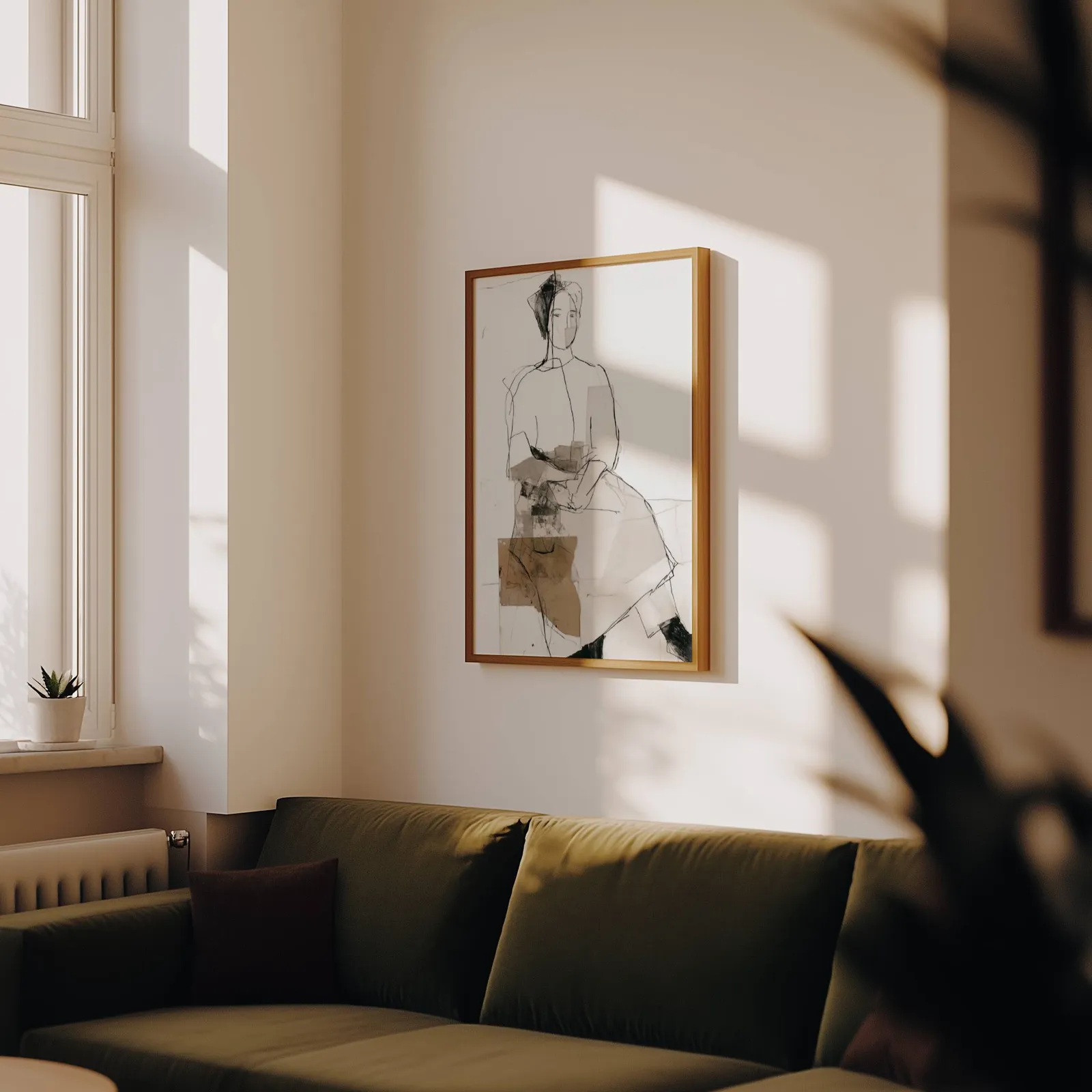 abstract seated figure line drawing wall art, above an olive velvet sofa in raking afternoon light