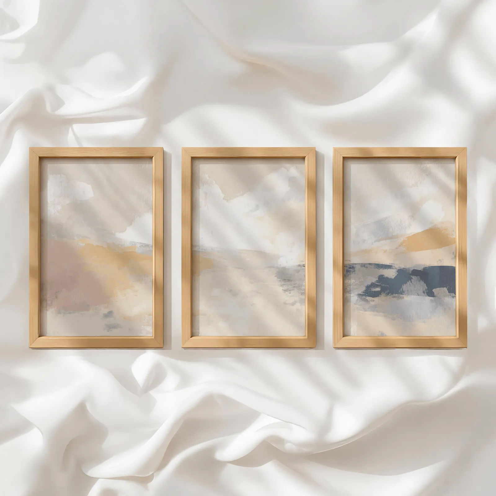 terracotta and blue abstract landscape wall art set of 3, in a row atop rumpled white silky fabric