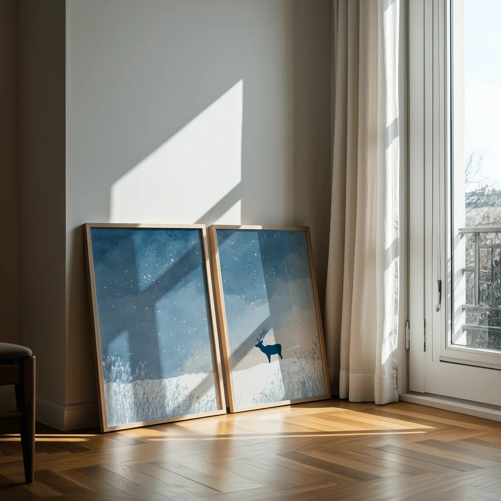blue winter landscape wall art set with deer silhouette, leaning against a sunlit wall by a curtained balcony door