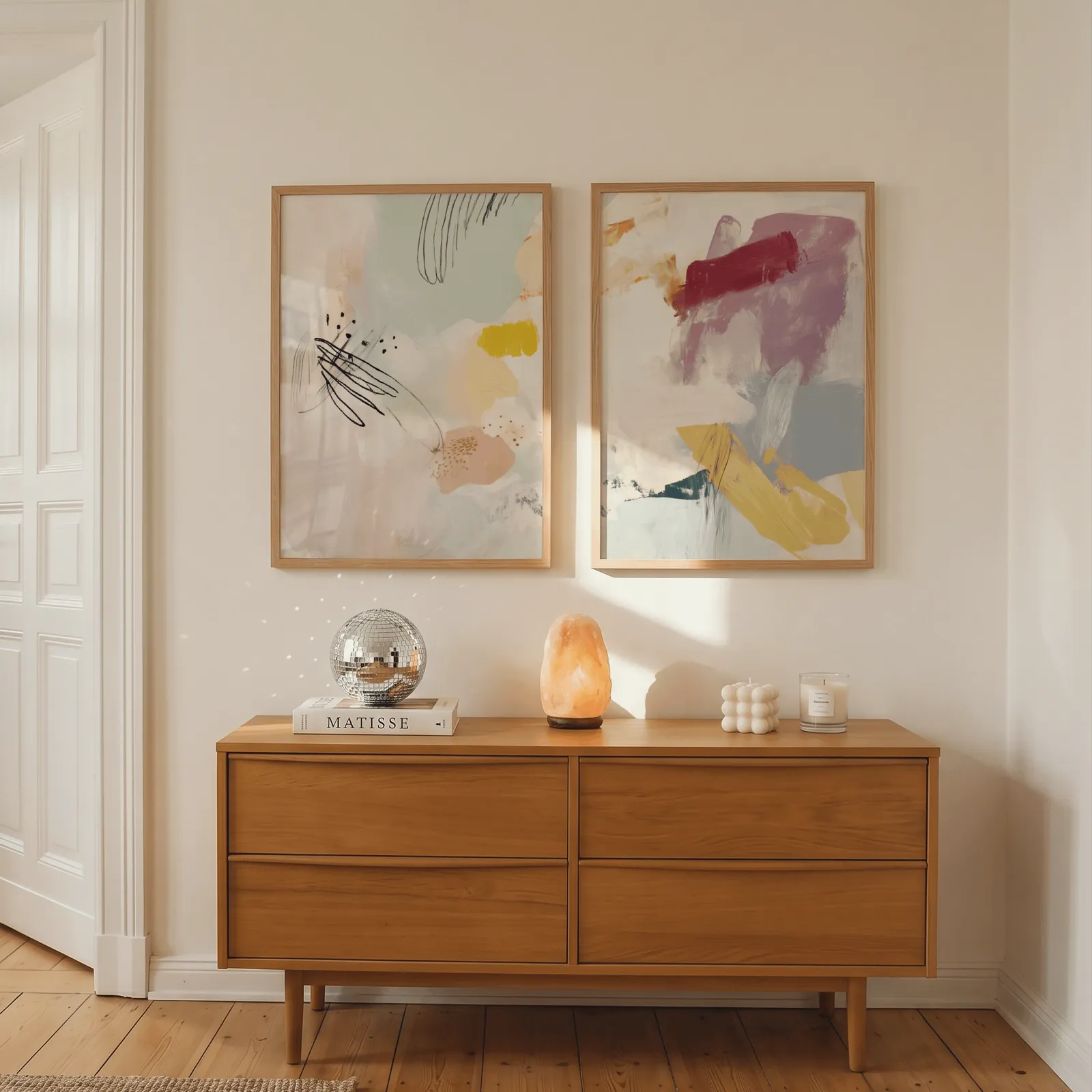 colorful abstract wall art set of 2, above a wooden dresser with a salt lamp and disco ball