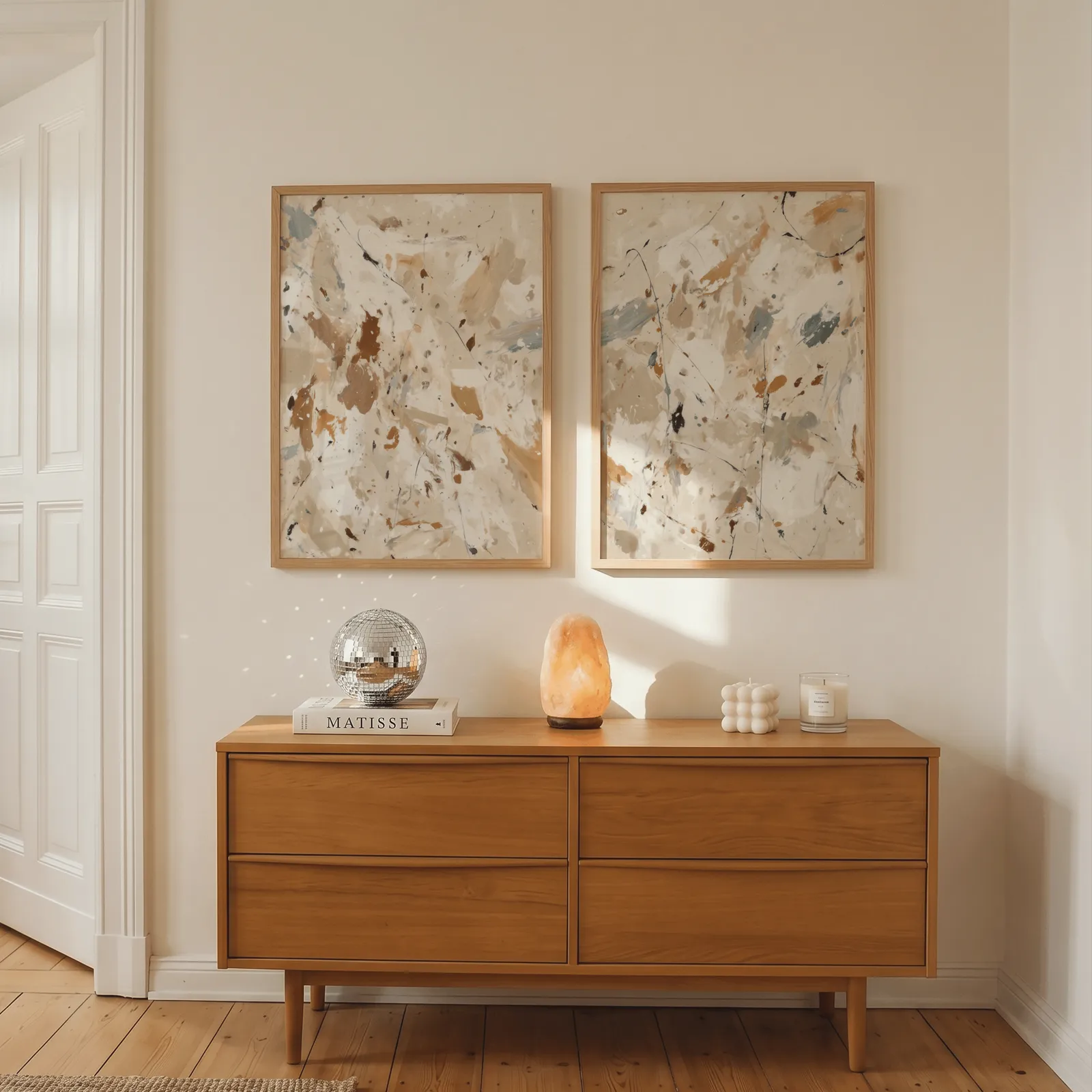 beige terracotta abstract splatter wall art set of 2, above a wooden dresser with a salt lamp and disco ball