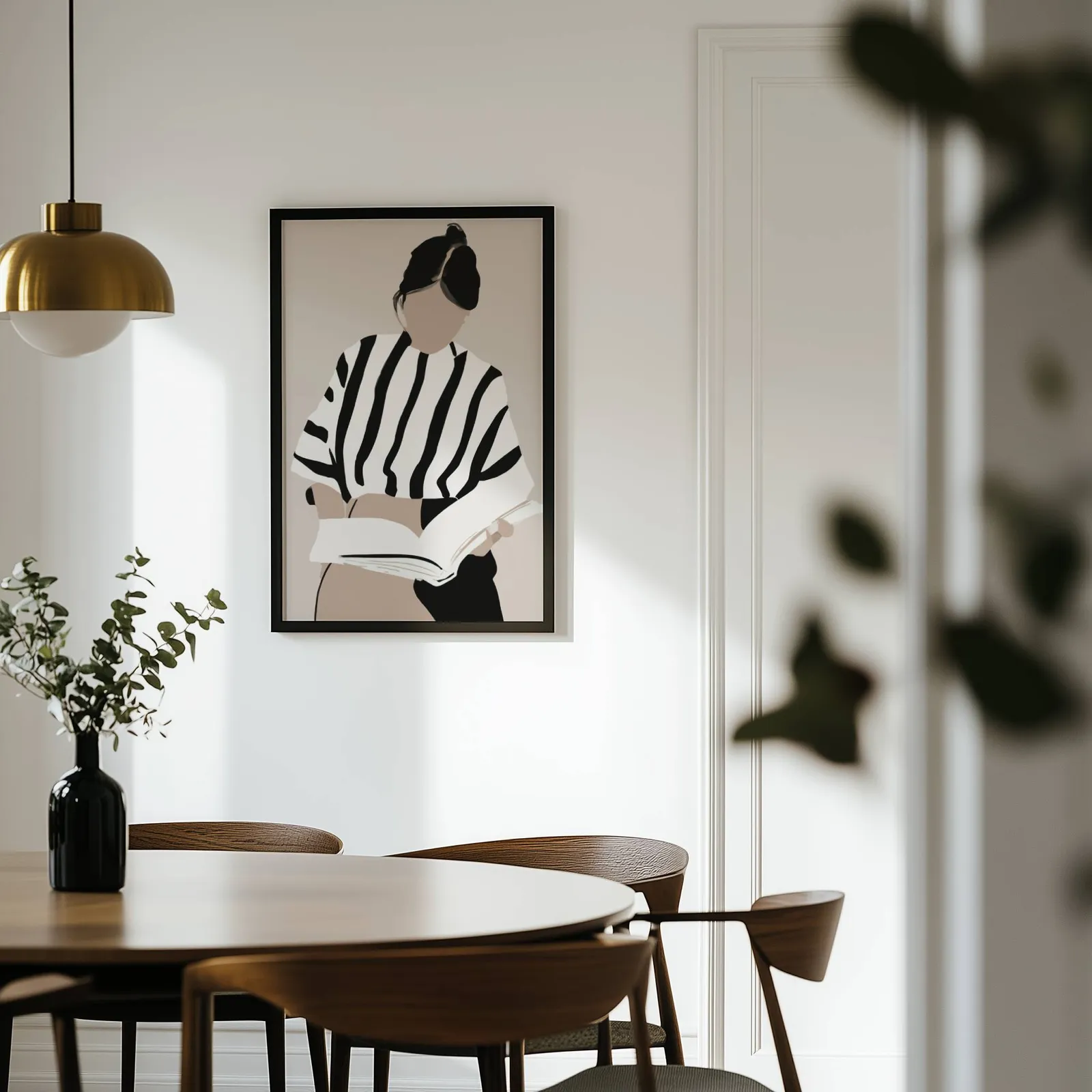 woman reading minimalist wall art, on a white wall above a round wooden dining table
