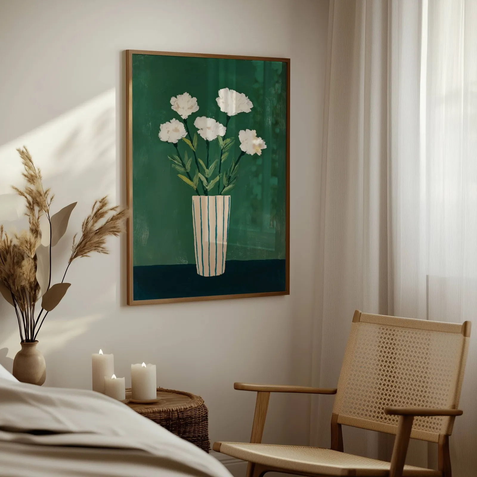 green floral wall art with white flowers in striped vase, above a woven side table with lit candles and pampas grass