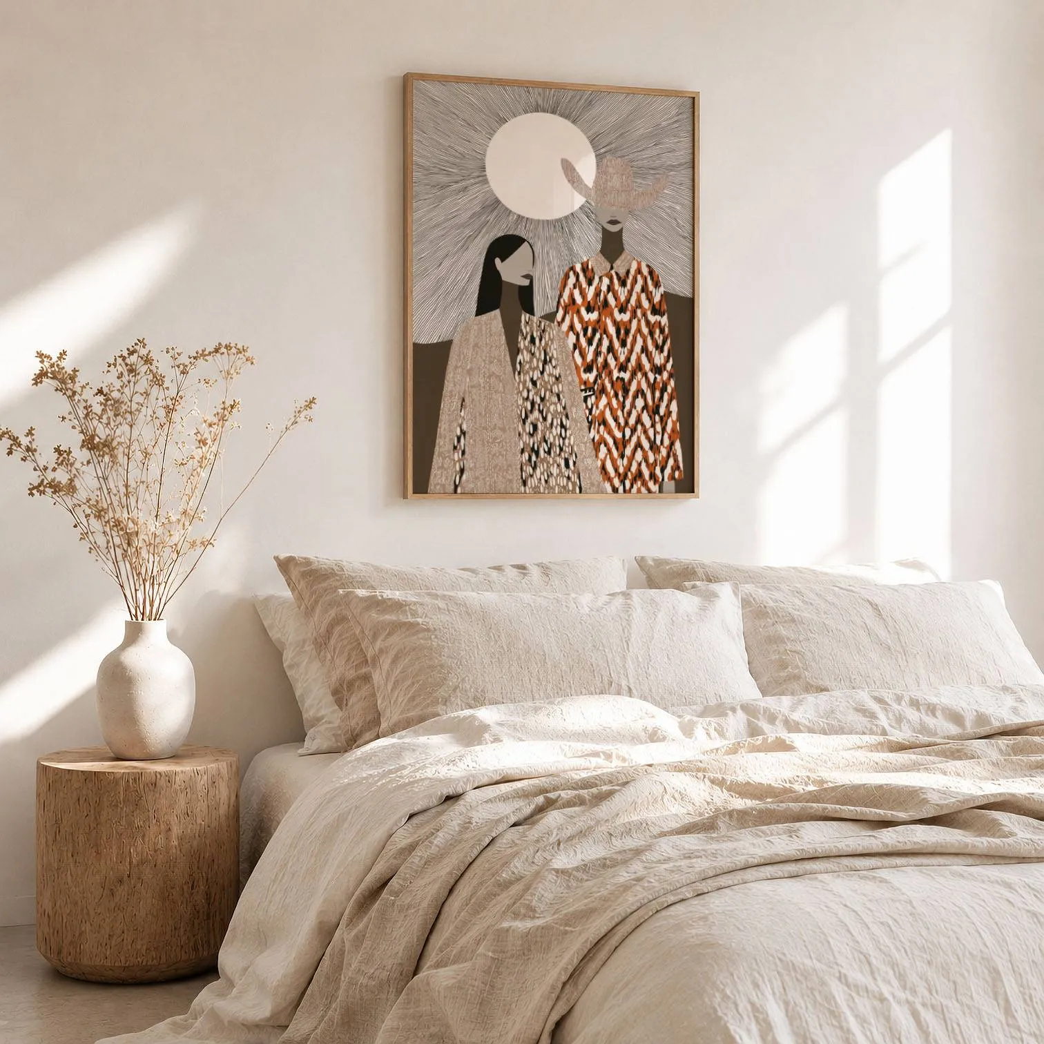 boho western wall art with two women in patterned cloaks, above a rumpled linen bed beside a stump side table