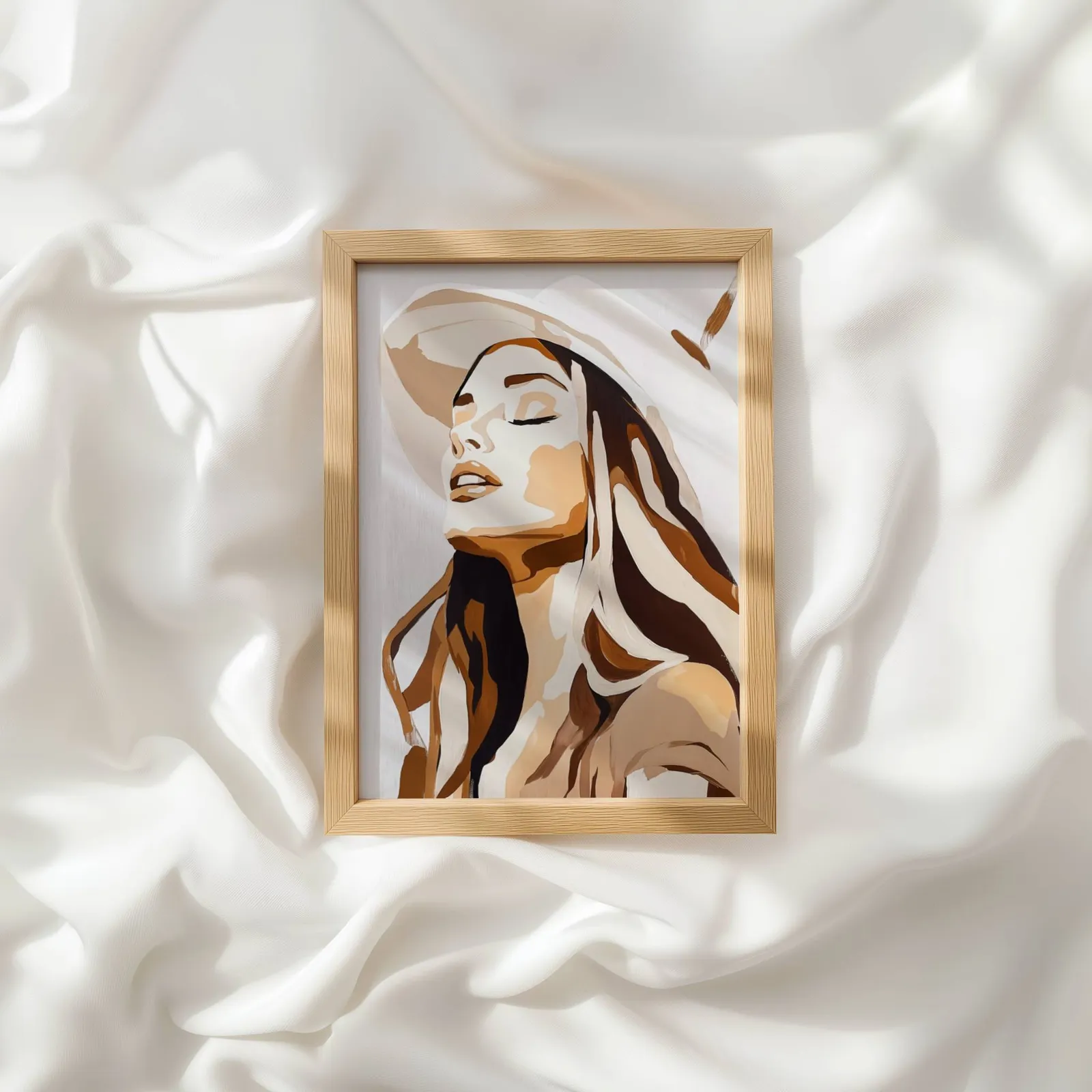 abstract woman wall art in brown and beige, resting atop rumpled white silky fabric